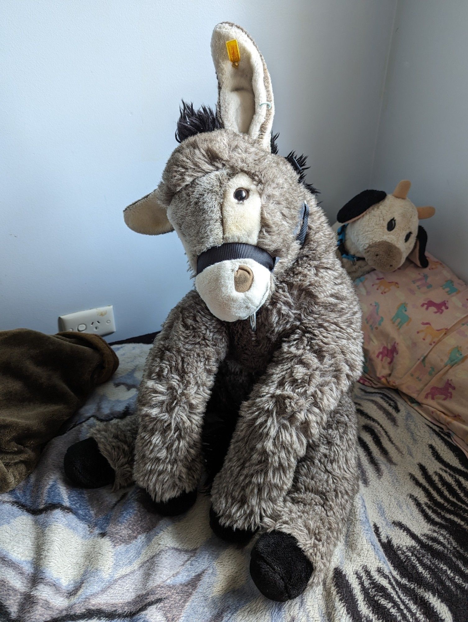 Plush donkey sitting on a bed