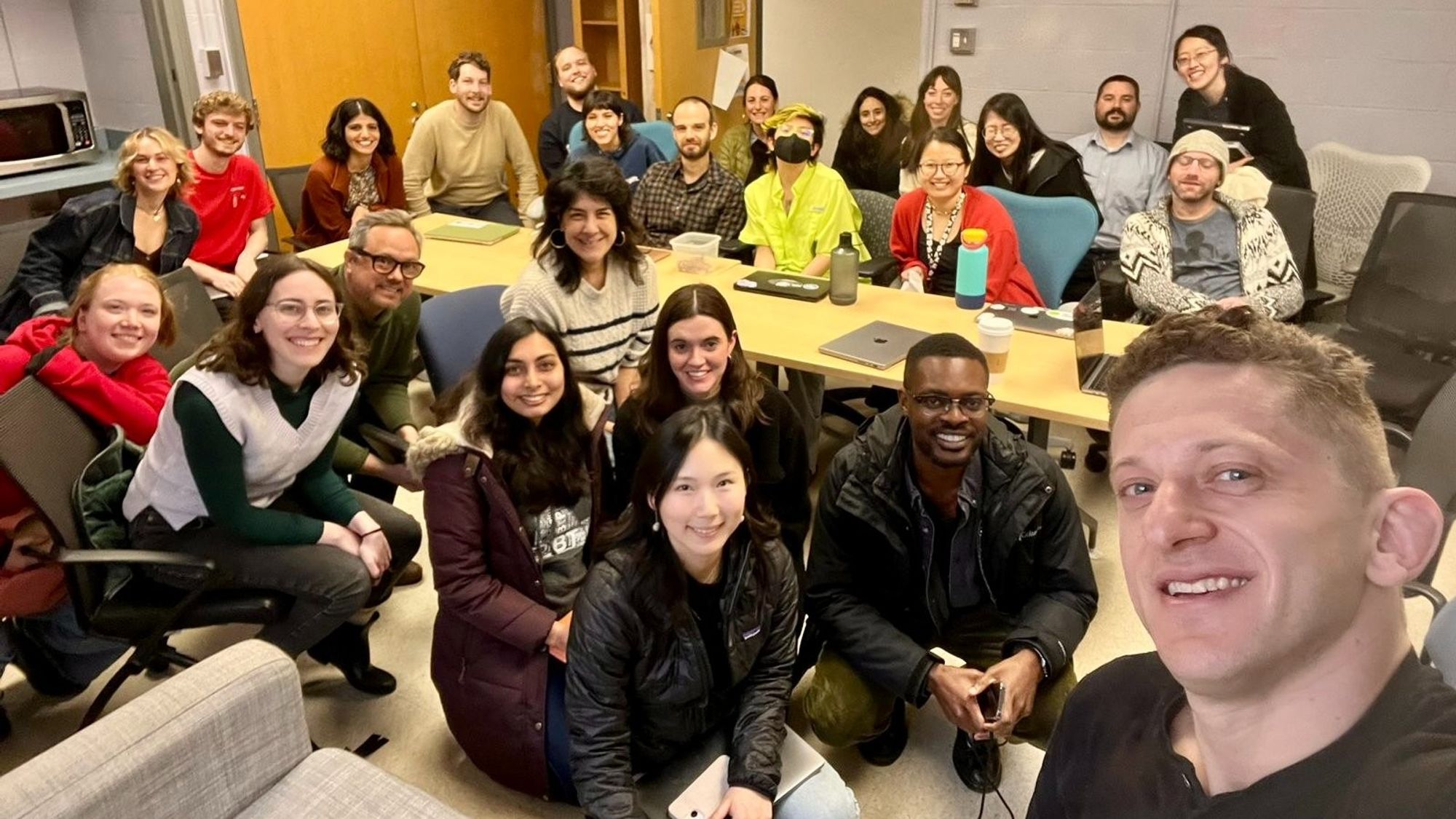 Photo of a 25-person reading group seated around a seminar table