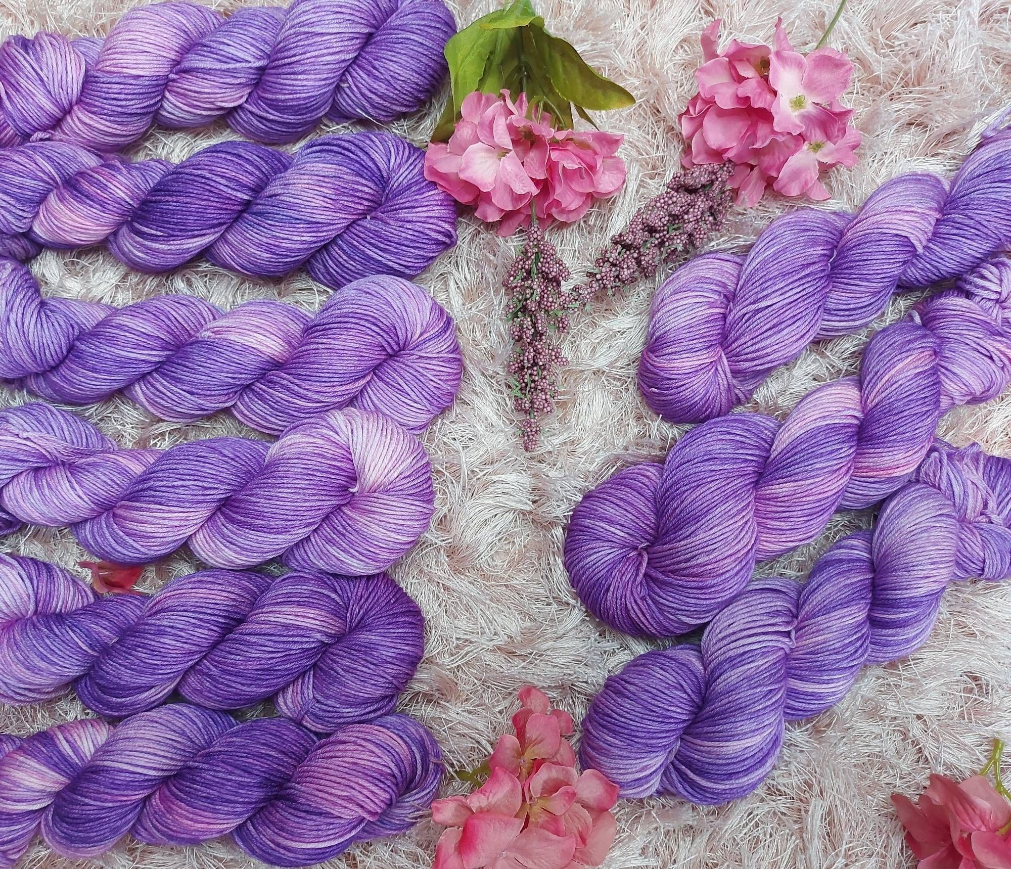 Purple and pink yarn, adorned with pink flowers.