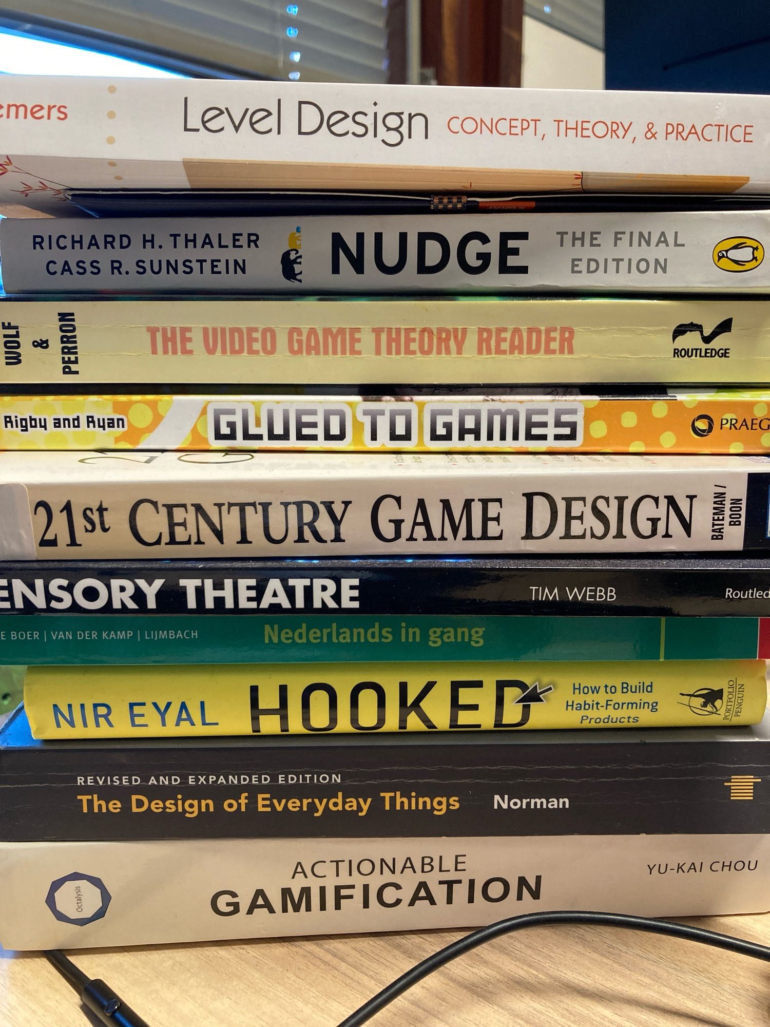 A stack of books on level design, nudge theory, game design, gamification and learning Dutch