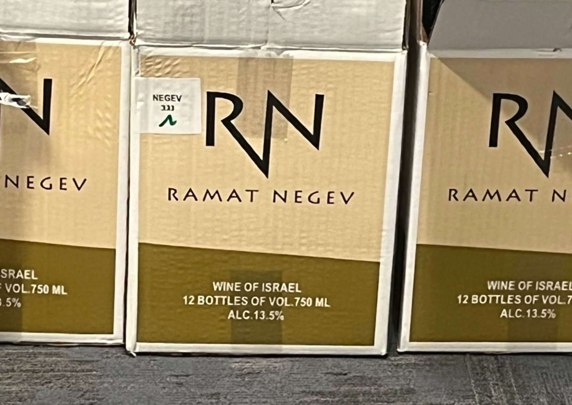 Boxes of Ramat Negev wine. Text on the bottom of the boxes reads: Wine of Israel. 12 bottles of volume 750 mL. Alcohol 13.5 percent.