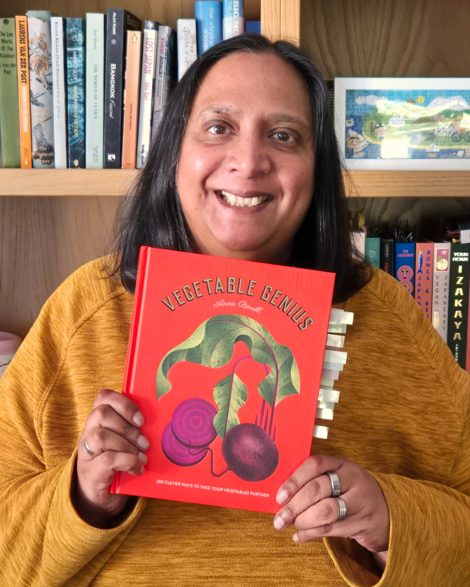 Me holding a copy of the Vegetable Genius cookbook