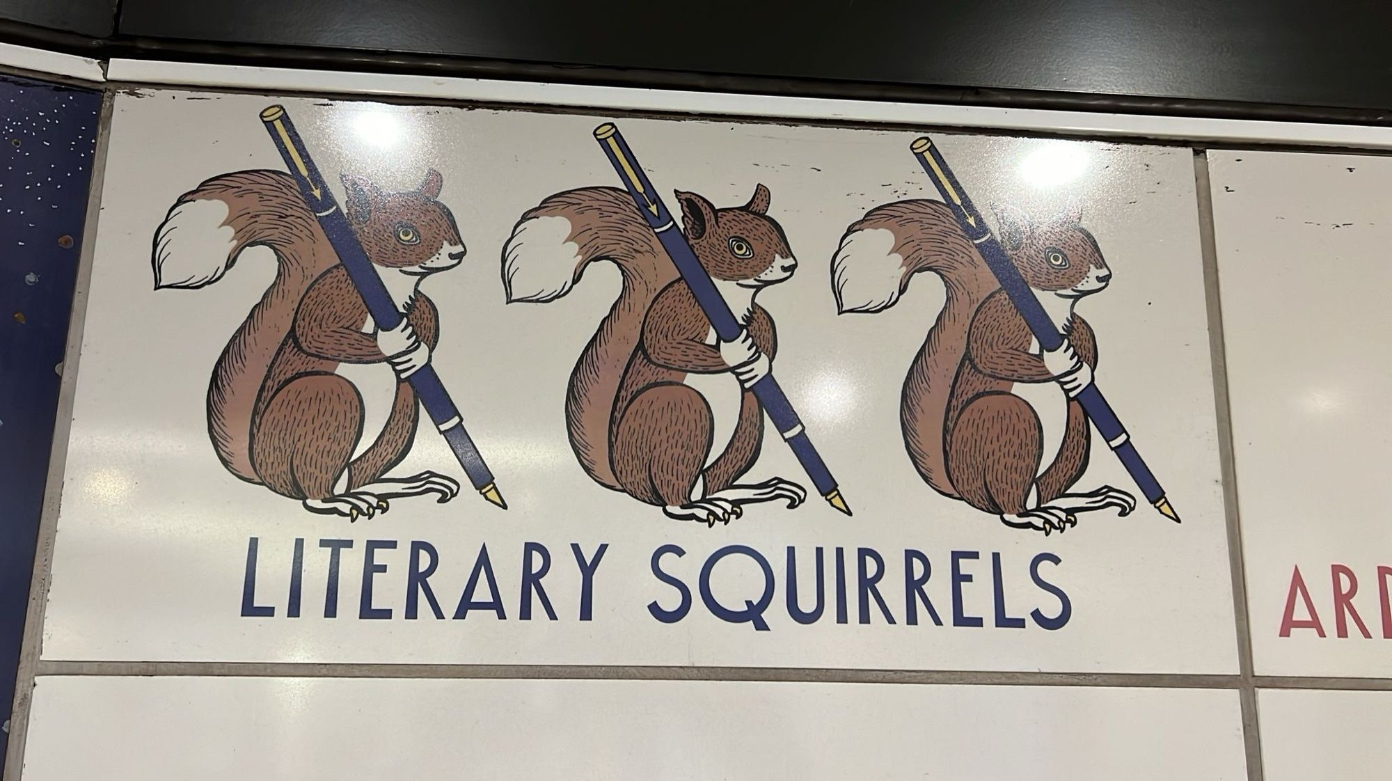 Mural detail. Three squirrels holding pens with the caption Literary Squirrels