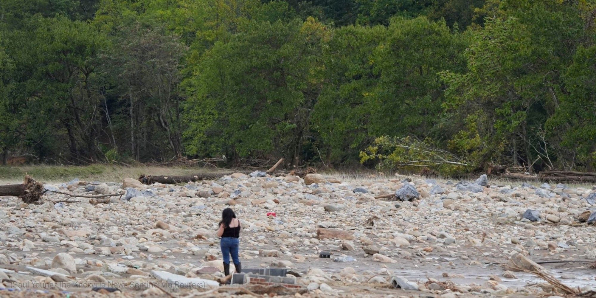 A woman stands on the site where the Jet Broadcasting radio station once stood in Erwin, Tenn., on Sept. 29. The entire building was swept away in the flooding cause by Tropical Storm Helene. Photo by Saul Young for The Knoxville News-Sentinel via Reuters.