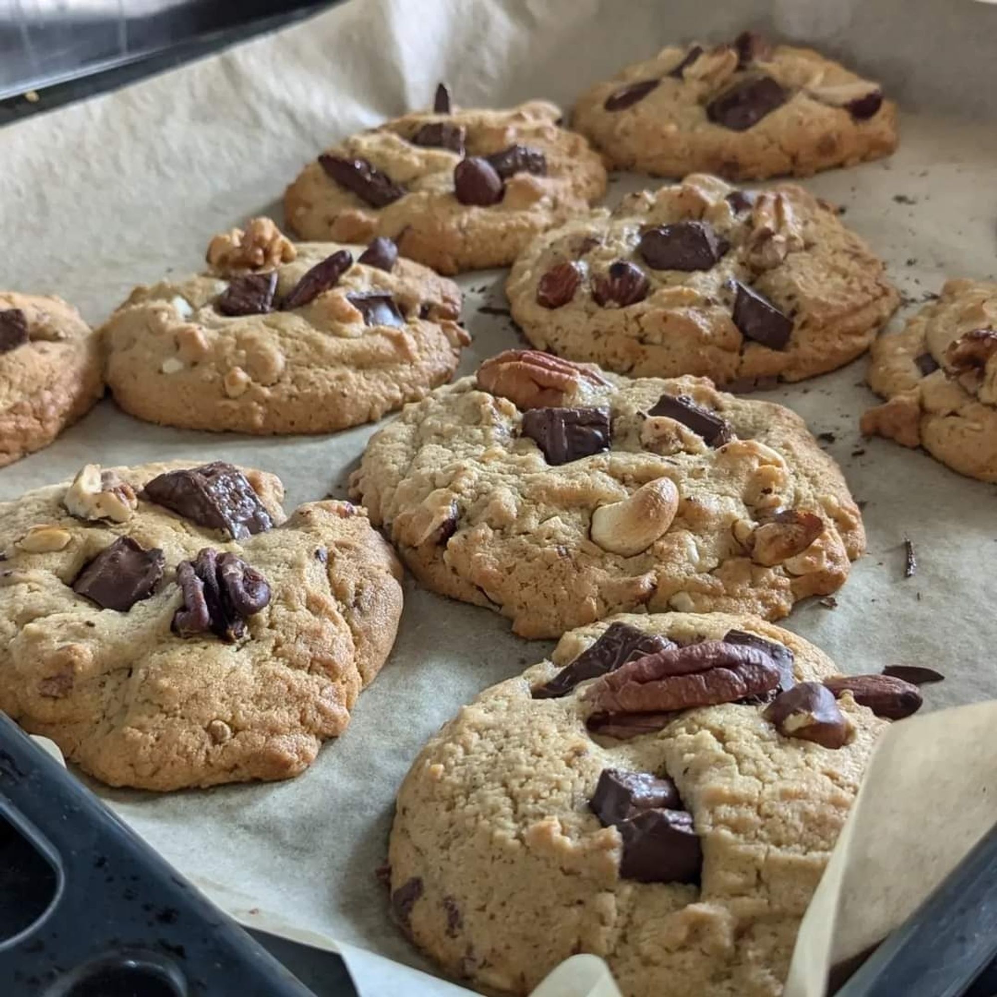 Photograph of an oven tray with around 8 chocolate chip cookies