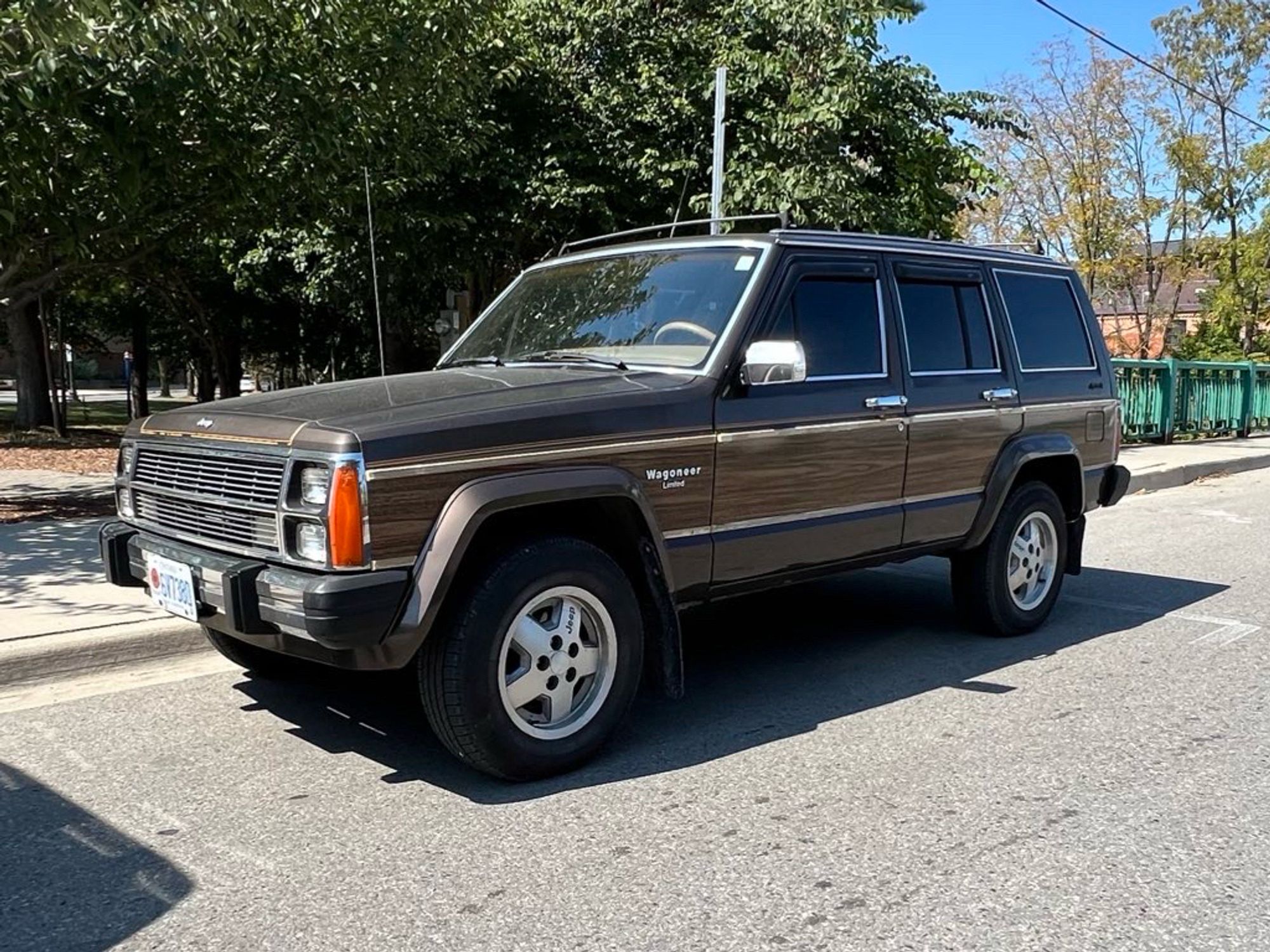 A brown jeep wagoneer with wood paneling on its side