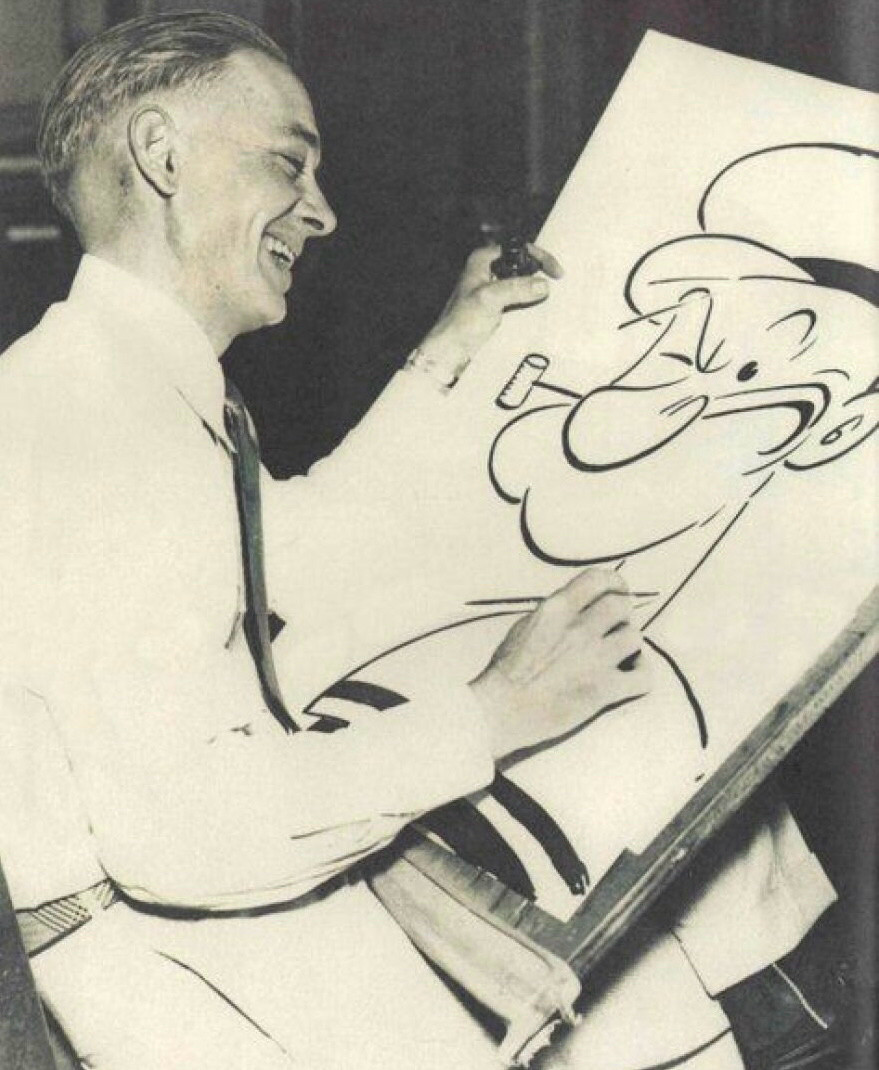 Photo of Segar smiling at a drawing of Popeye