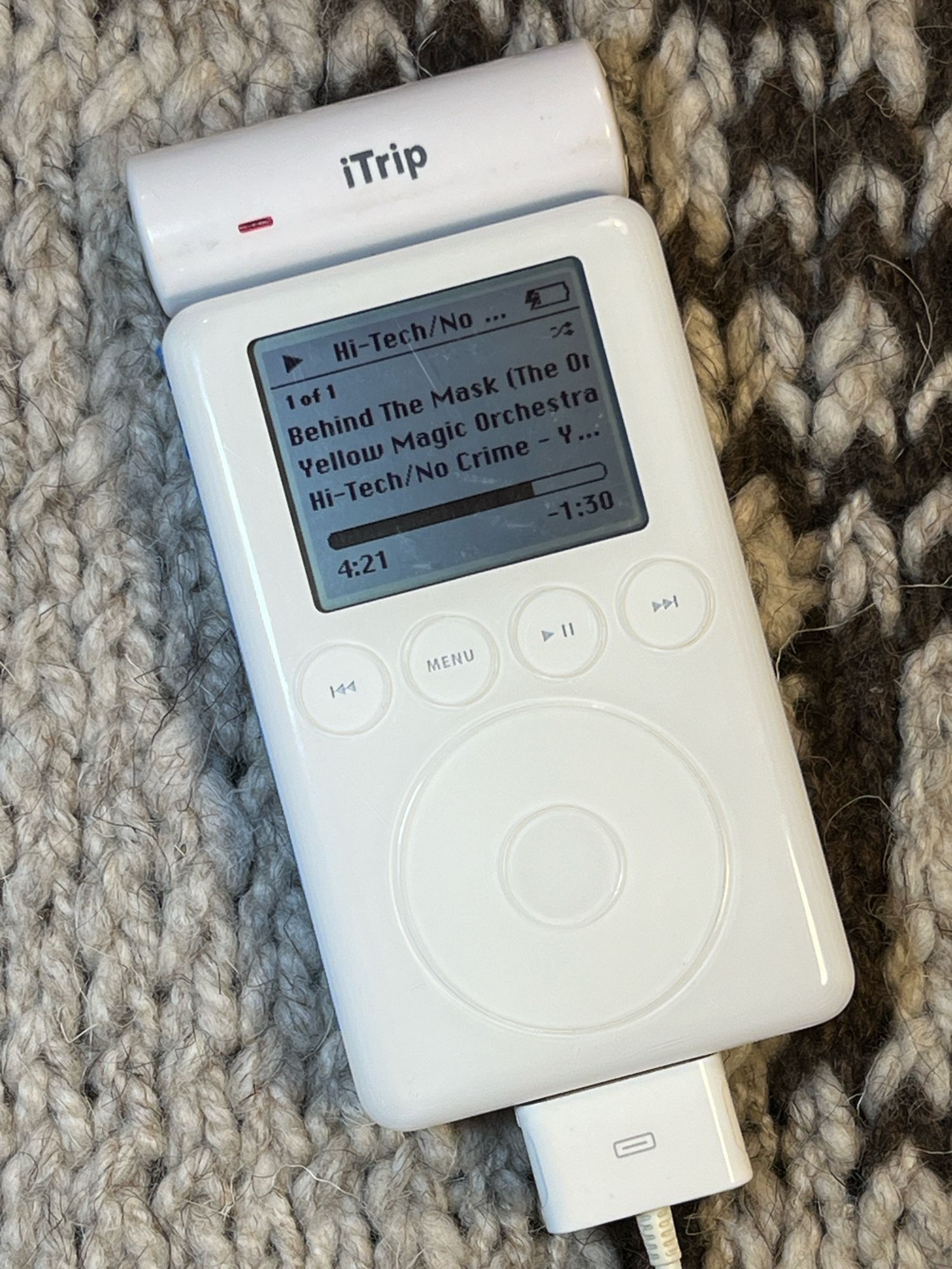 A white iPod 3G with an iTrip FM transmitter stuck on top.