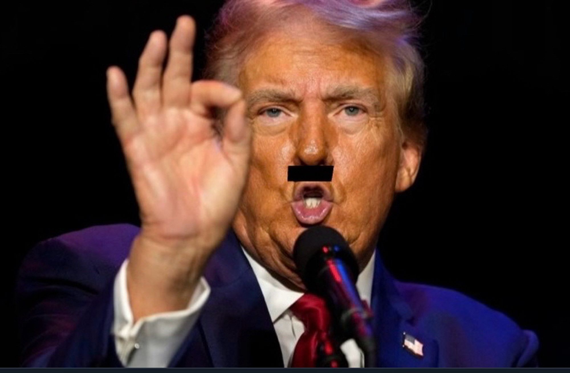 An close up image of an angry Donald Trump speaking at one of his rallies spewing hate with a Hitler mustache drawn on it and his hand raised