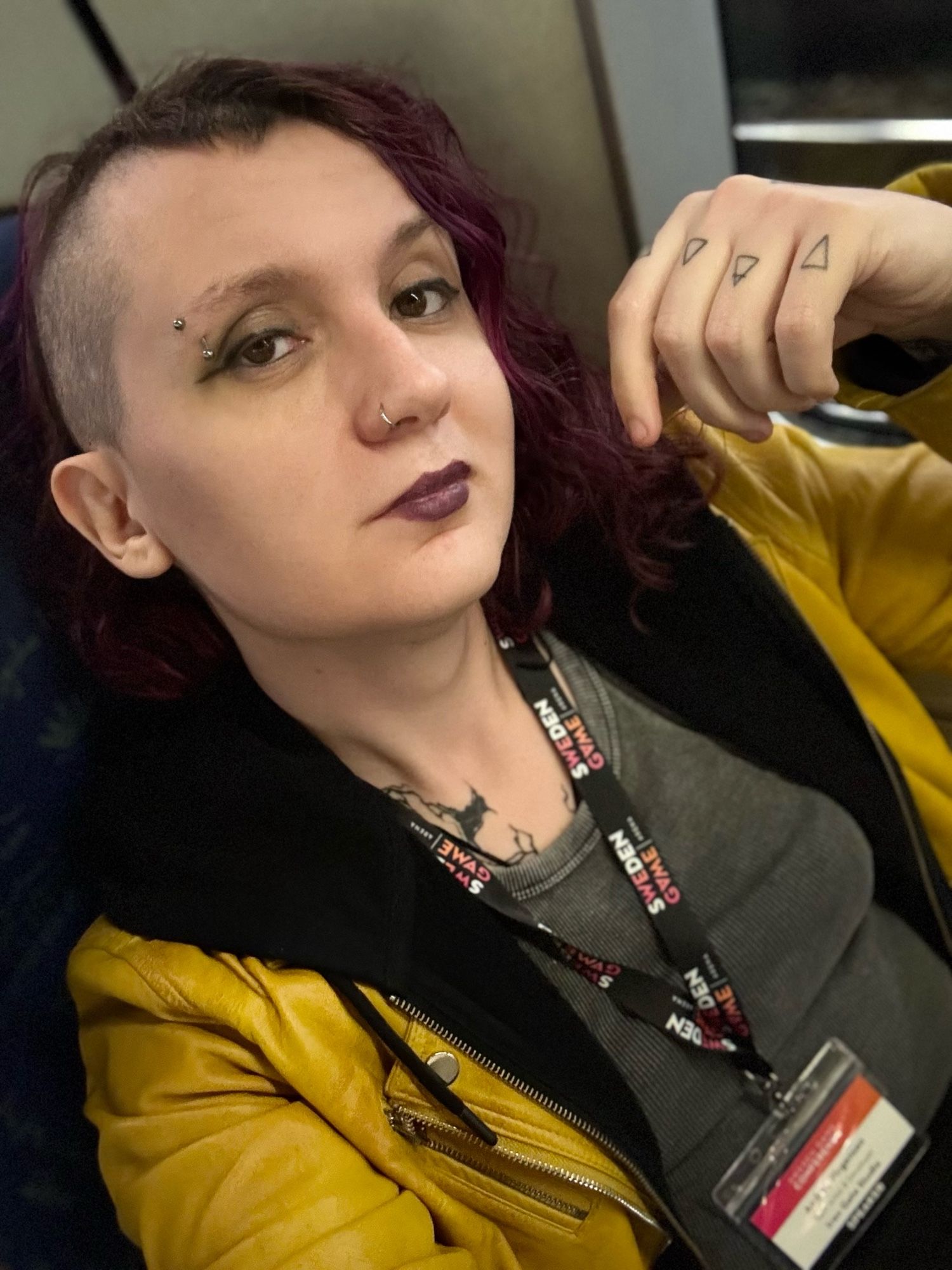 Andrea looking at the camera, with a conference badge around her neck