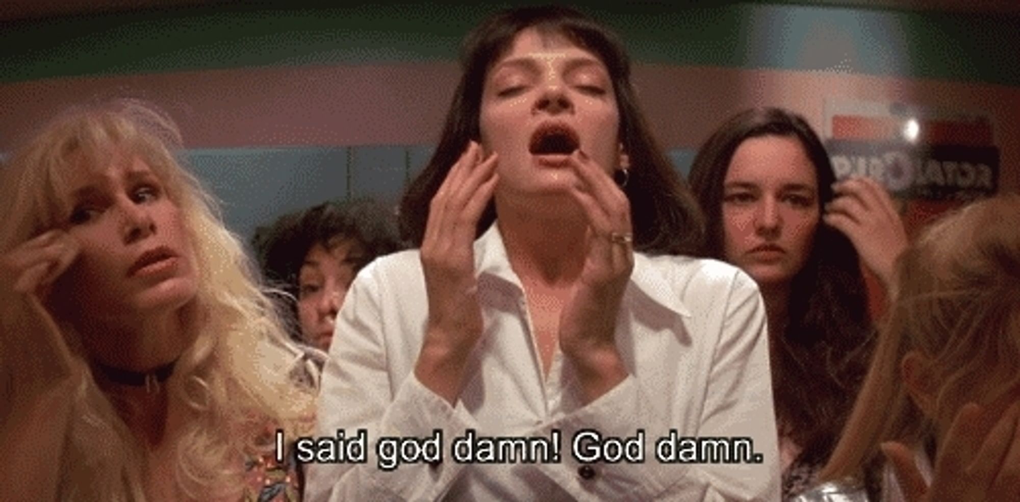 Still from the movie Pulp Fiction show Mia after doing some coke in a bathroom mirror with text that says "I said God damn! God damn."