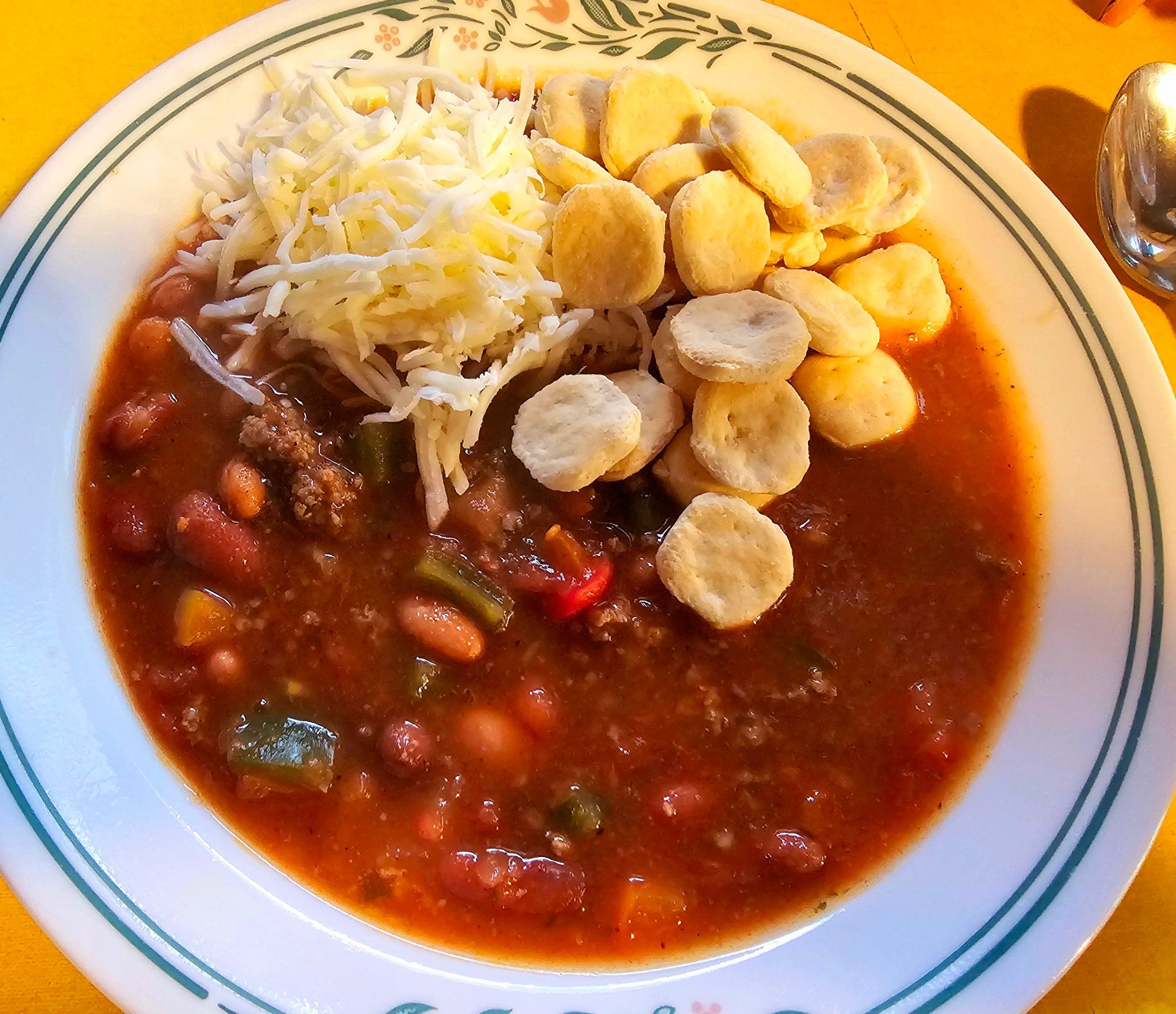 Vegetable soup with ground beef, tomato, bell peppers, onion, carrots, celery, kidney beans, pinto beans, jalapeño, chili and adobo, cilantro and chili spices. It is topped with cheese and oyster crackers for dinner tonight on the ol homestead. 