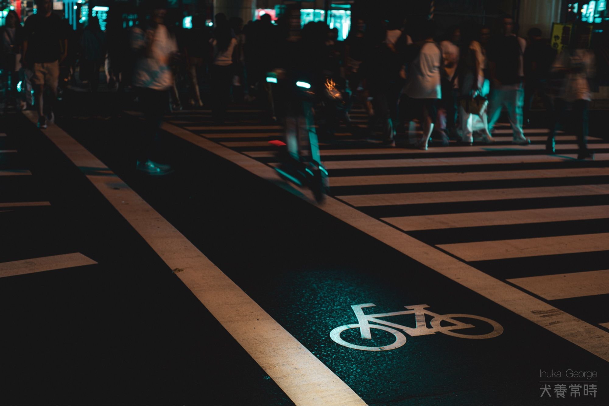 夜の横断歩道。自転車横断帯に電動キックボードの前照灯が当たっている