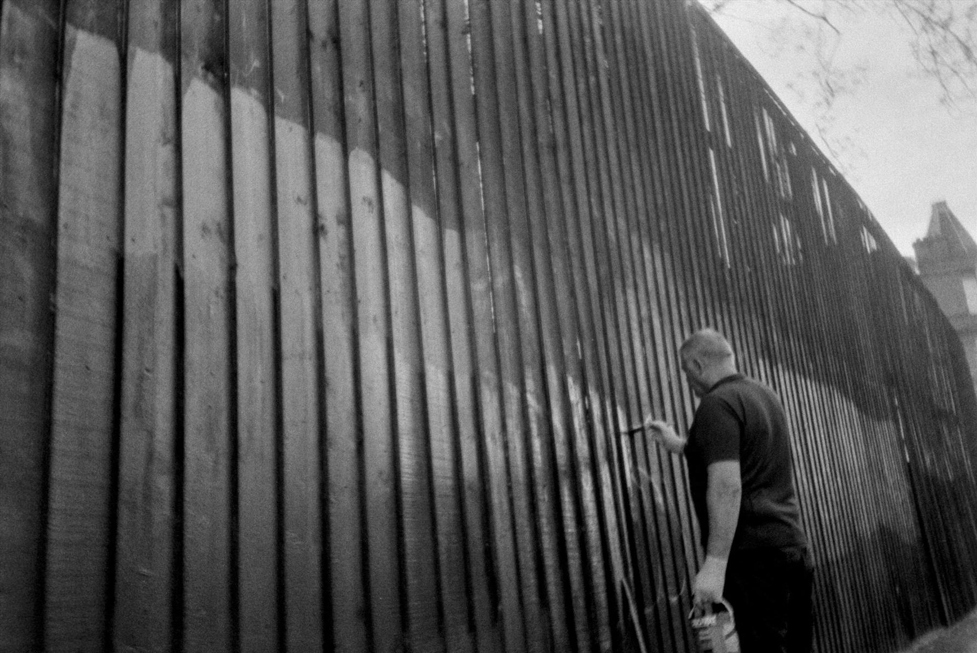 A man paints over graffiti in the south side of glasgow 