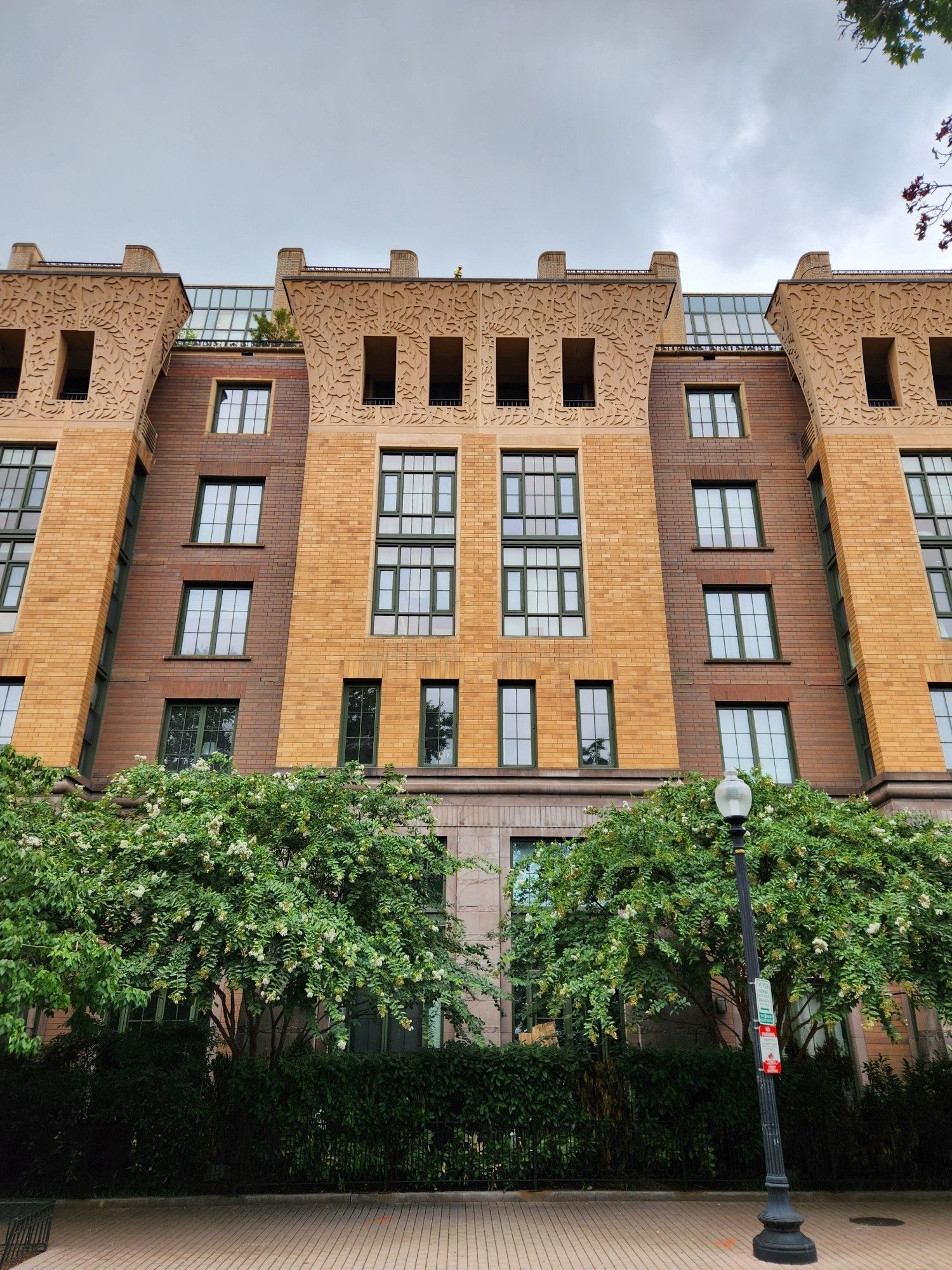 A view of one portion of the lower facade shows sculpted curved column tops extending outward from the building's walls