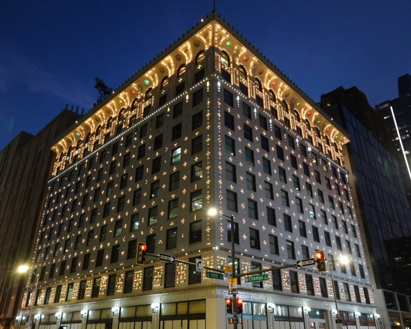 A photo of the building from the quoted post lit up at night with patterns of thousands of exterior light bulbs making facade detail forms on the walls and cornices