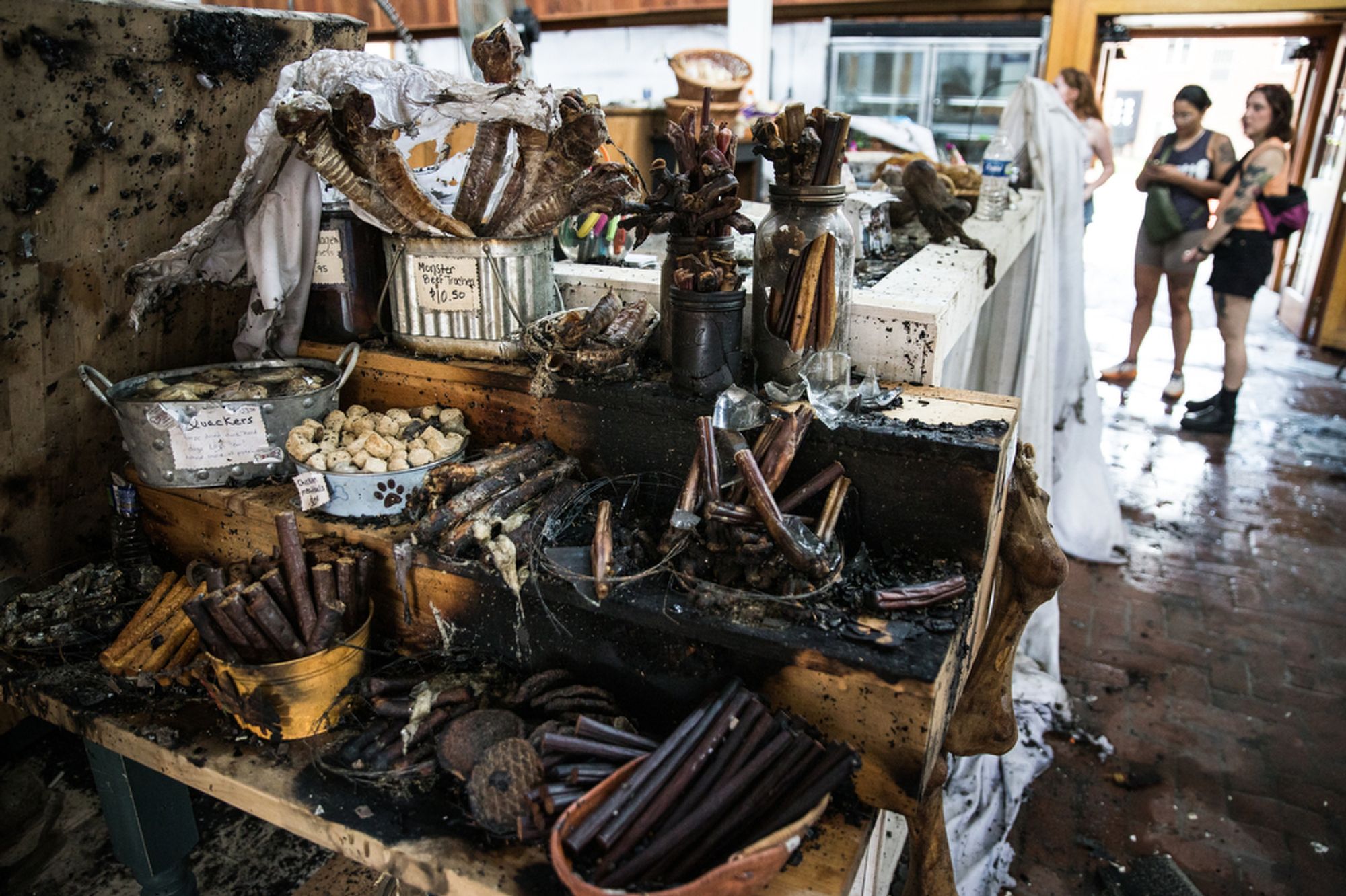 A vegetable stand covered in soot and debris following a fire.