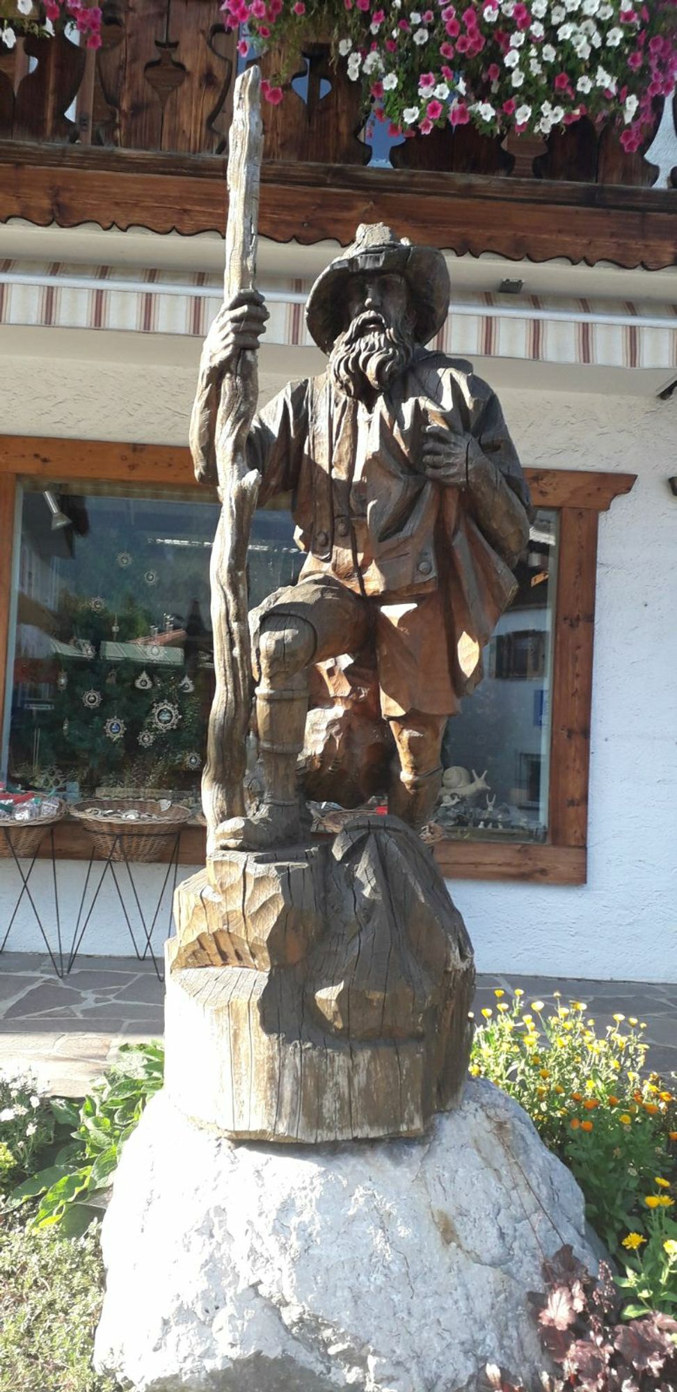 Een houtsnijwerk van een bebaarde man met hoed en wandelstok in Zugspitze dorp Grainau.