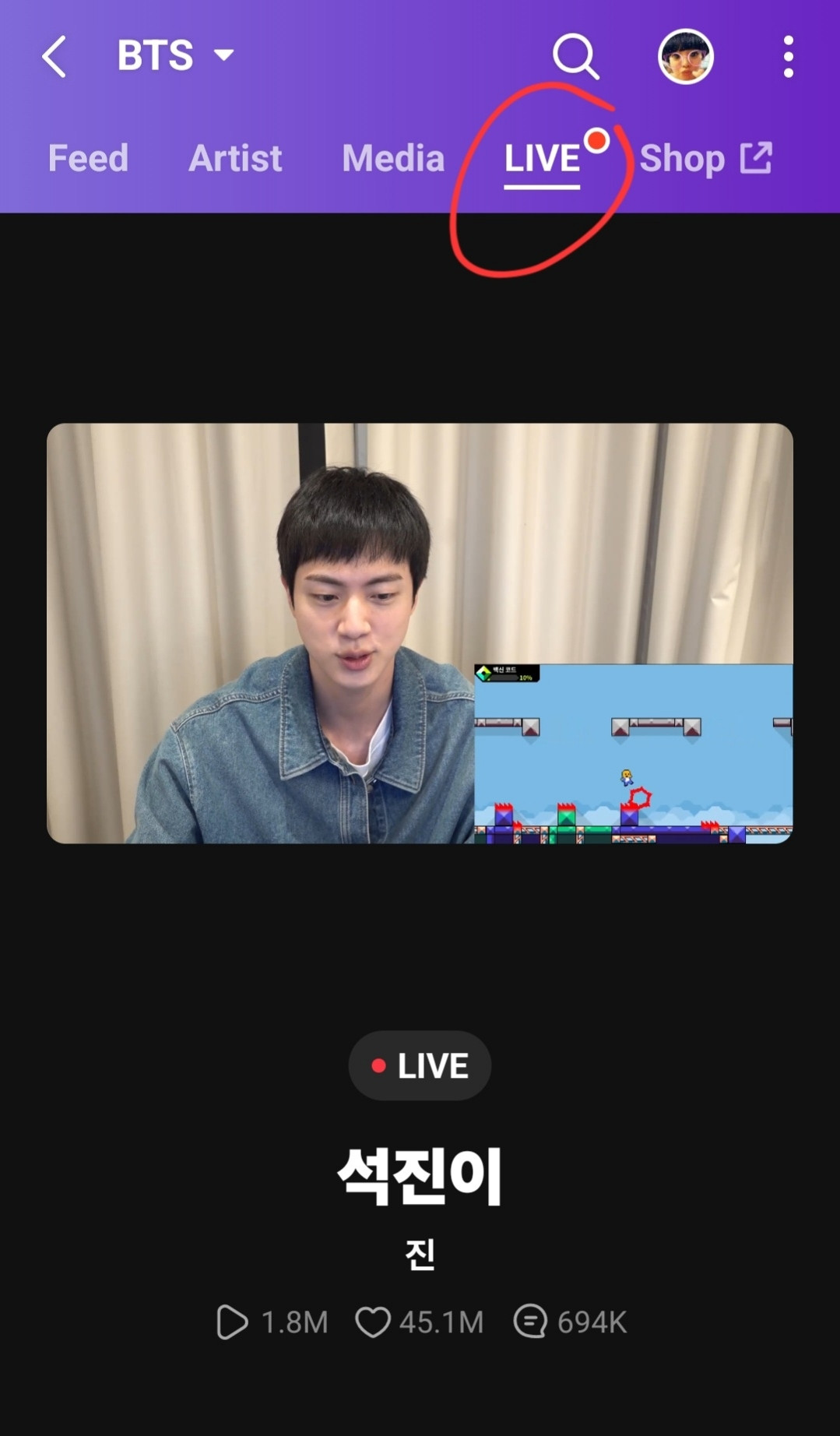 It's a notification on the Weverse app telling the audience that jin is live. In this screenshot, jin is seen playing a video game.