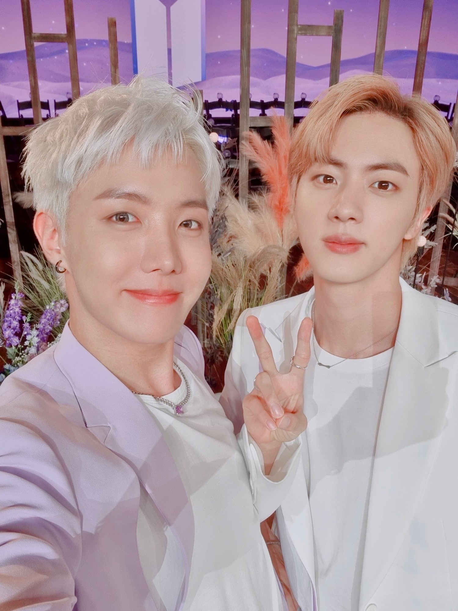 It's a selfie of hobi with platinum hair and jin, pinkish hair (holding a peace sign) during PTD era.