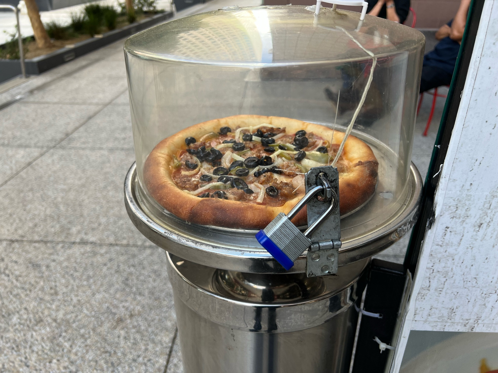 A pizza in a glass case with a lock on it