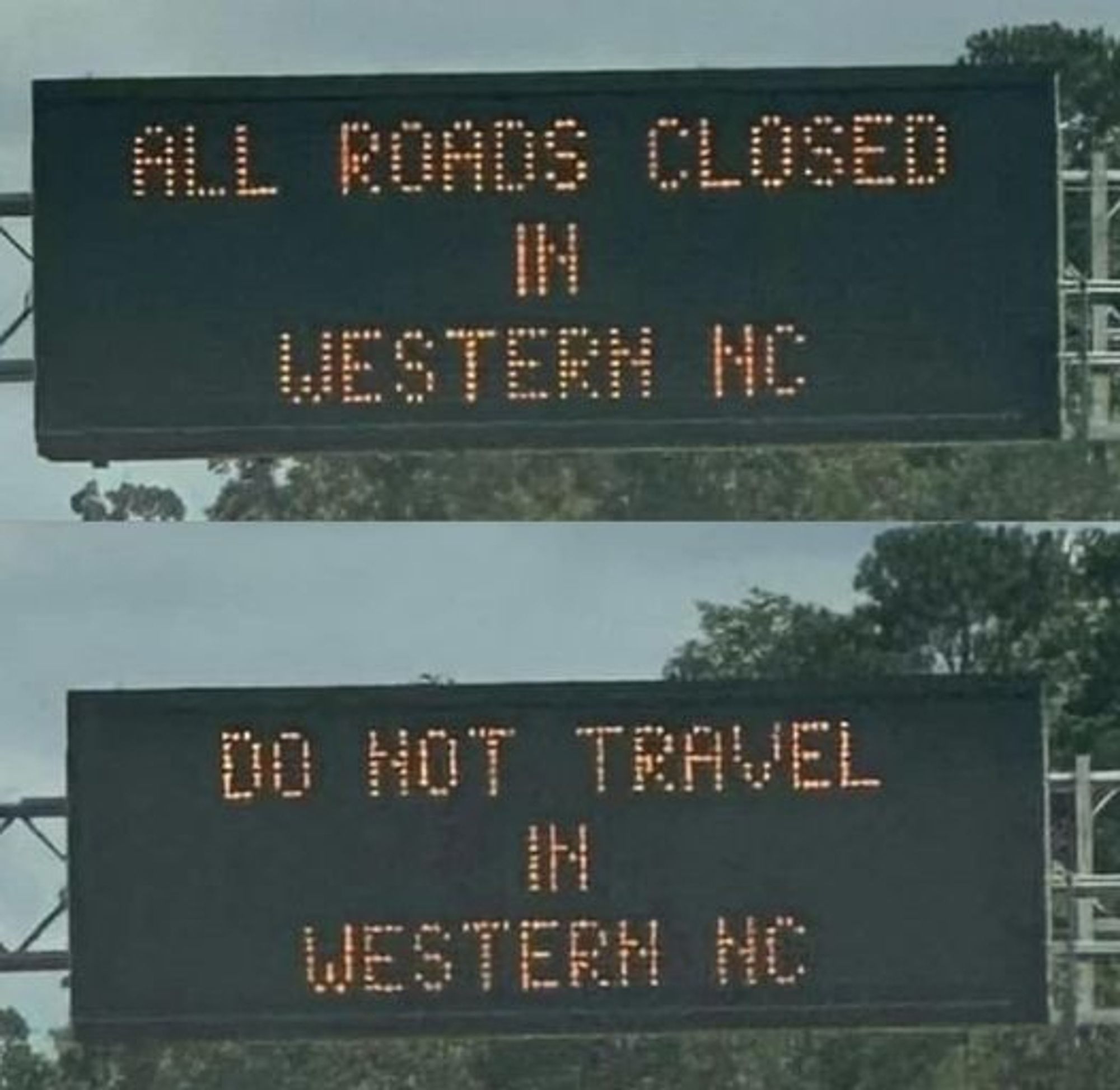 Department of Transportation electronic sign, reading "ALL ROADS CLOSED IN WESTERN NC" and then "DO NOT TRAVEL IN WESTERN NC"