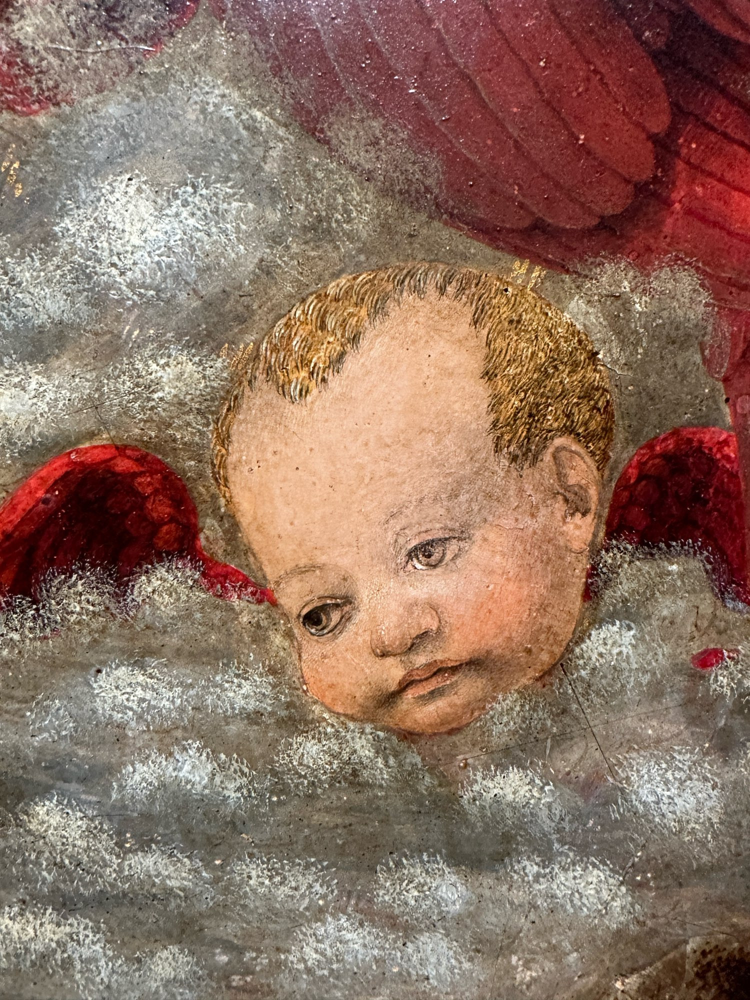 A painting of an old looking cherub who is severely unimpressed. 