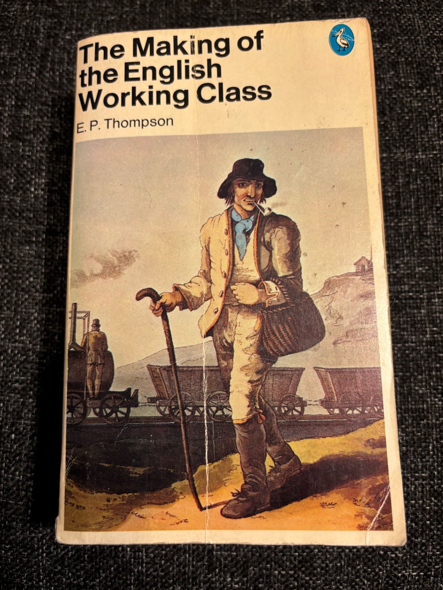 The cover of a Pelican edition of EP Thompson’s ‘The Making of the English Working Class’ showing a working man, smoking a pipe, walking past coal wagons