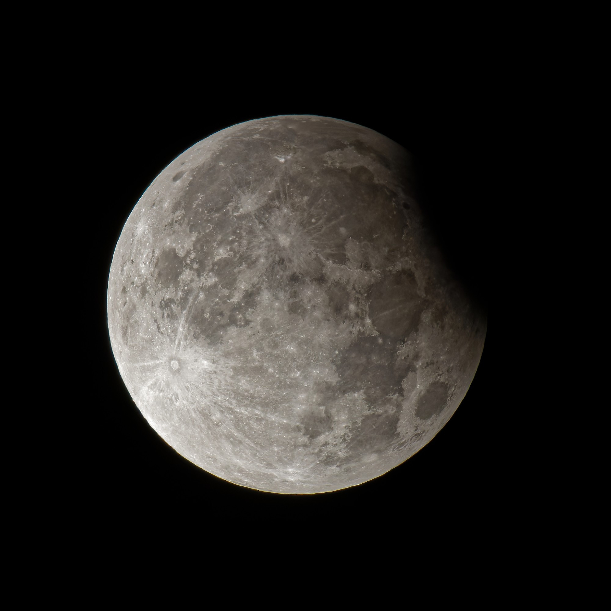 the full moon showing a dark eclipsed area in the upper right