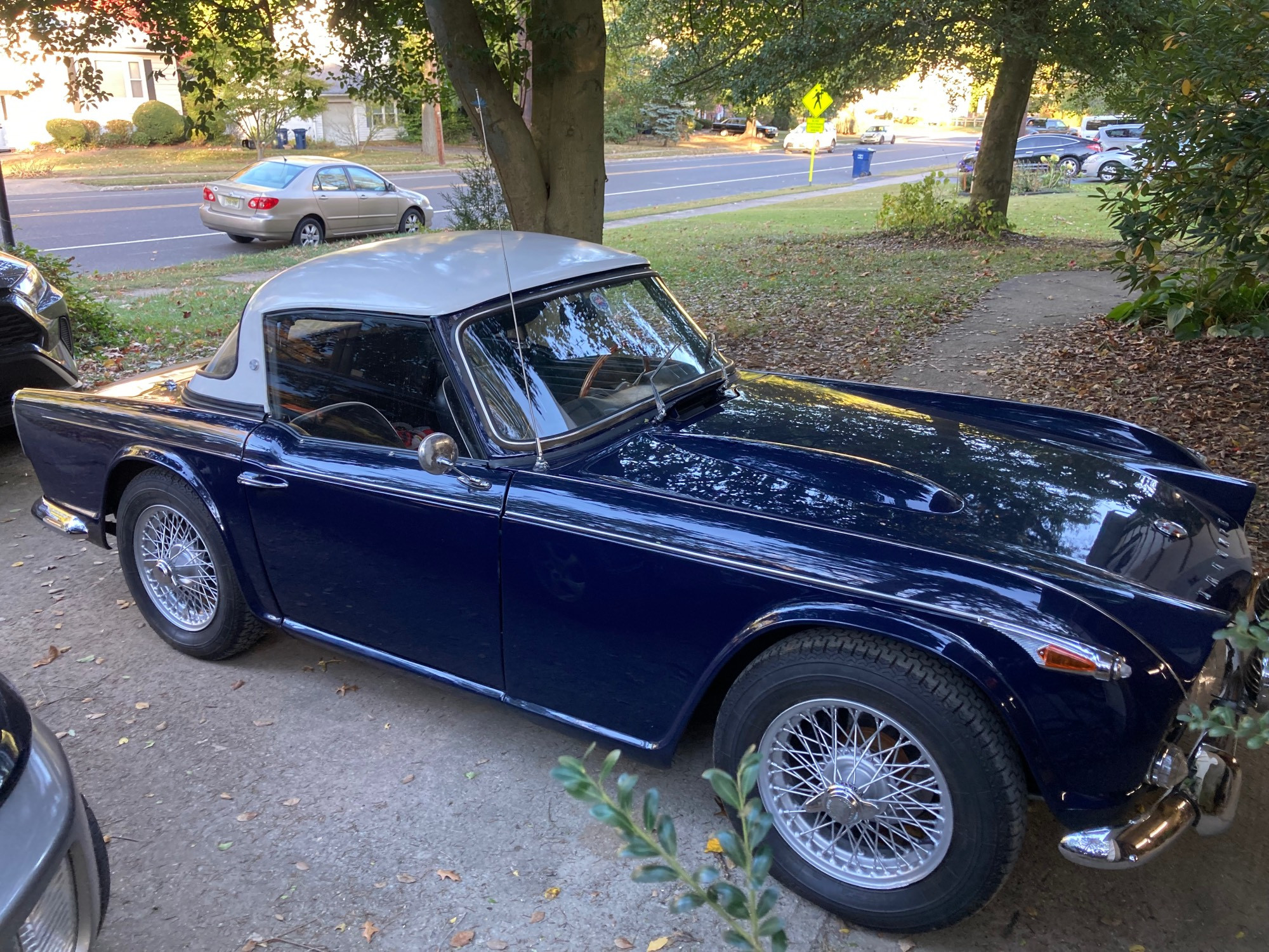 A photo of a 1966 Triumph TR4A in Royal Blue with wire wheels and a vintage Parrish Plastics hard top in contrasting white.