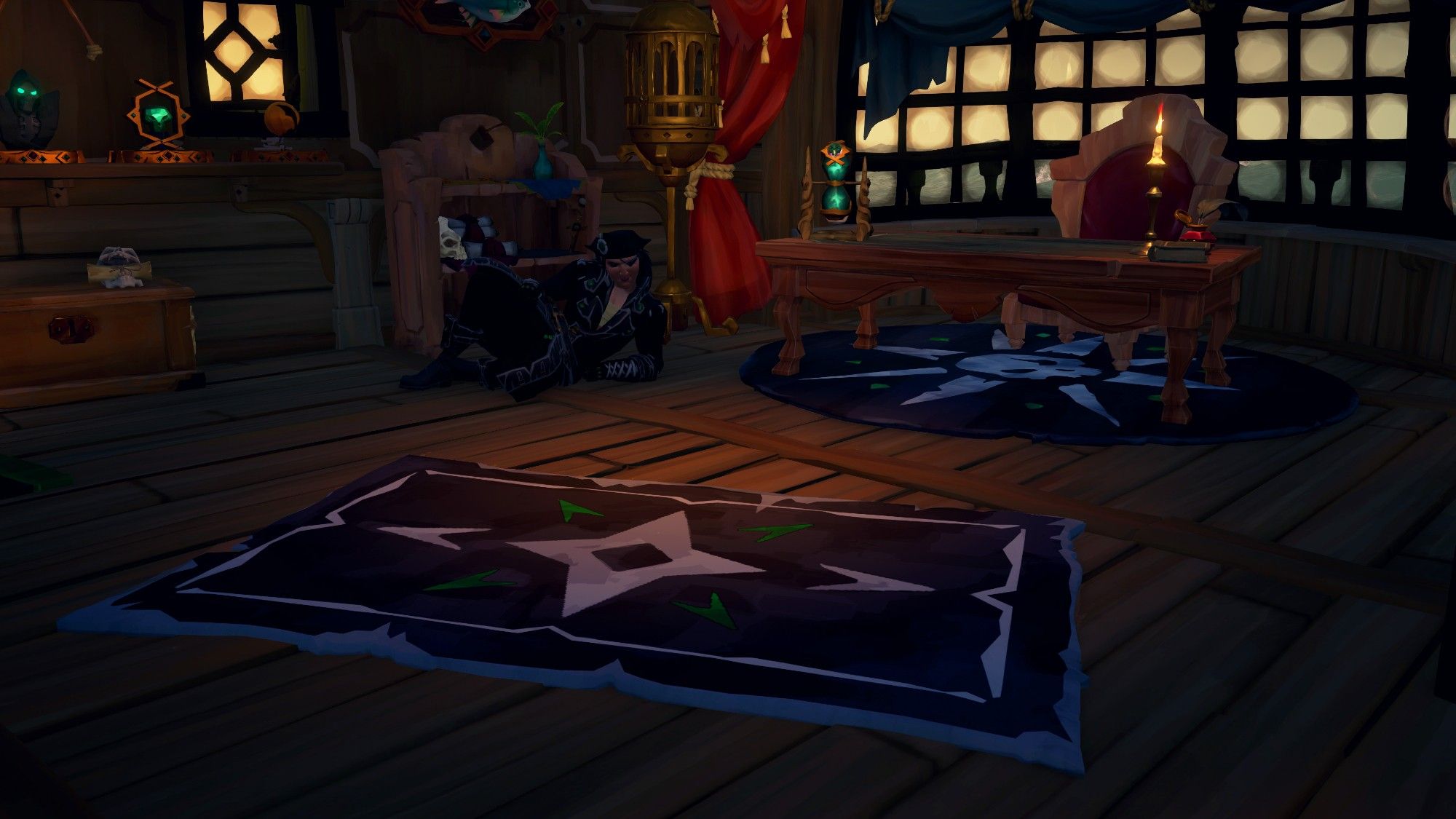 A screenshot from the game Sea of Thieves. Laid out on the floor of a Captain's cabin are two rugs, a circular one underneath a table, and a large rectangular one in the centre of the cabin. The rugs have a pointed, navigation symbol design in black and white with green accents. A pirate poses on the floor behind them.