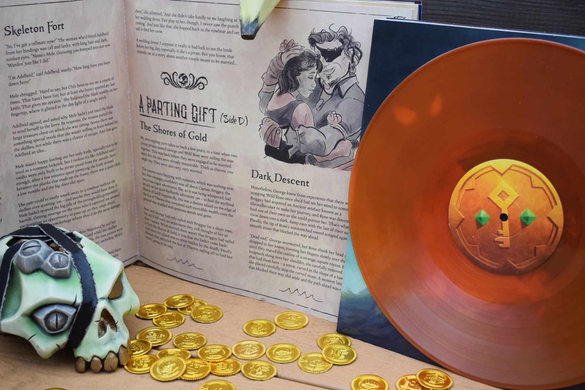 An orange vinyl rests upright next to a page of words related to Sea of Thieves. Lovely words, we're sure, all contained in the Sea of Thieves Vinyl Soundtrack.