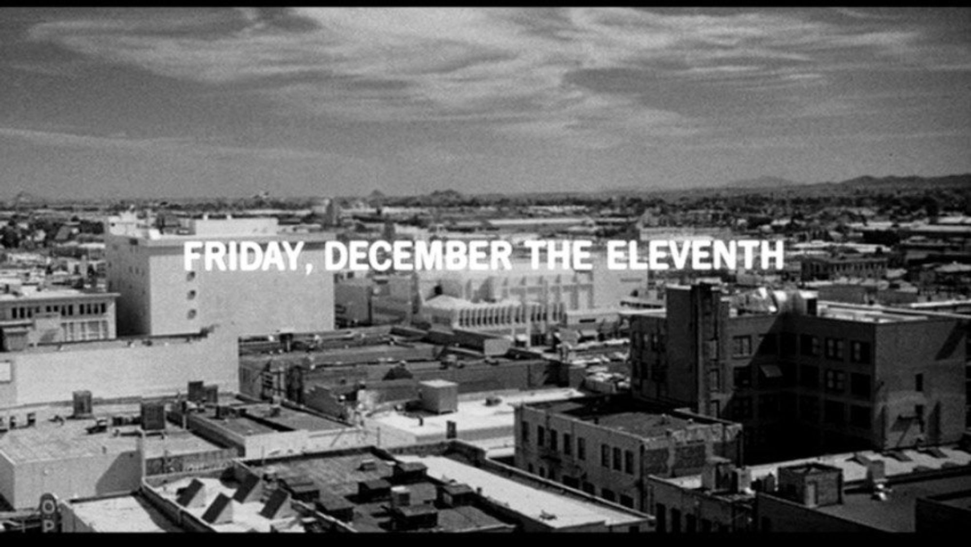 Title card at the start of Alfred Hitchcock's Psycho (1960): "FRIDAY, DECEMBER THE ELEVENTH" in white lettering over a black and white cityscape of Phoenix, Arizona.