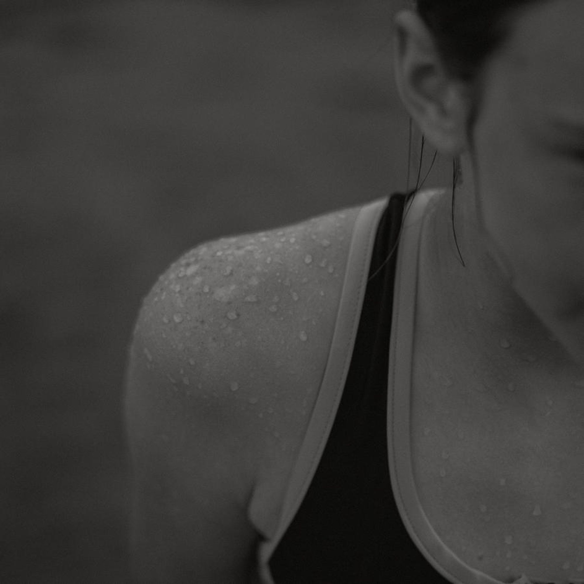 b&w photo of water beaded on a slightly sunburnt shoulder.