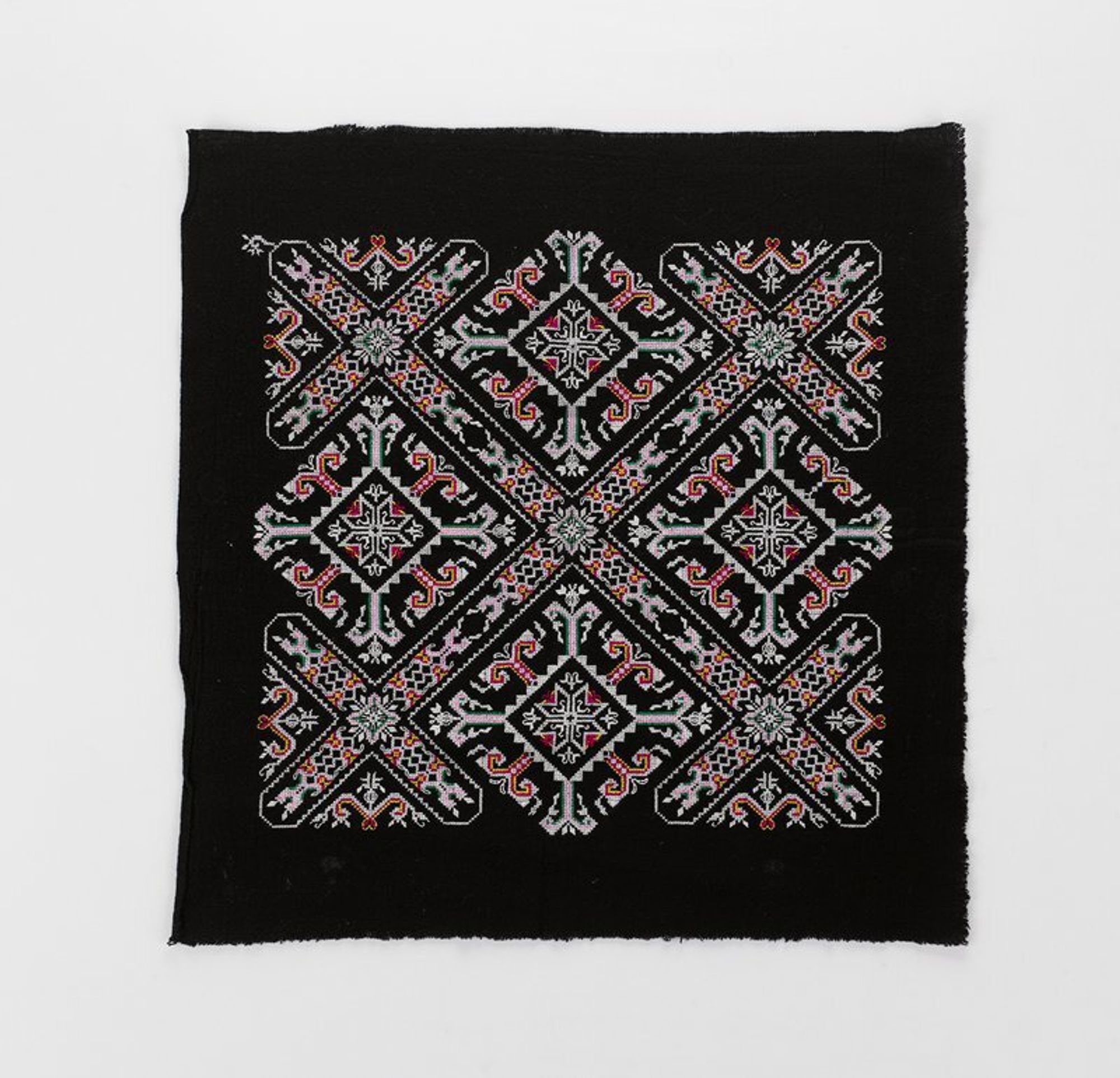 white, pink, red, green and yellow discontinuous supplementary weft patterning on black field; large central cross design with smaller crosses at corners on same arms as center design, large square floral patterns, top and bottom