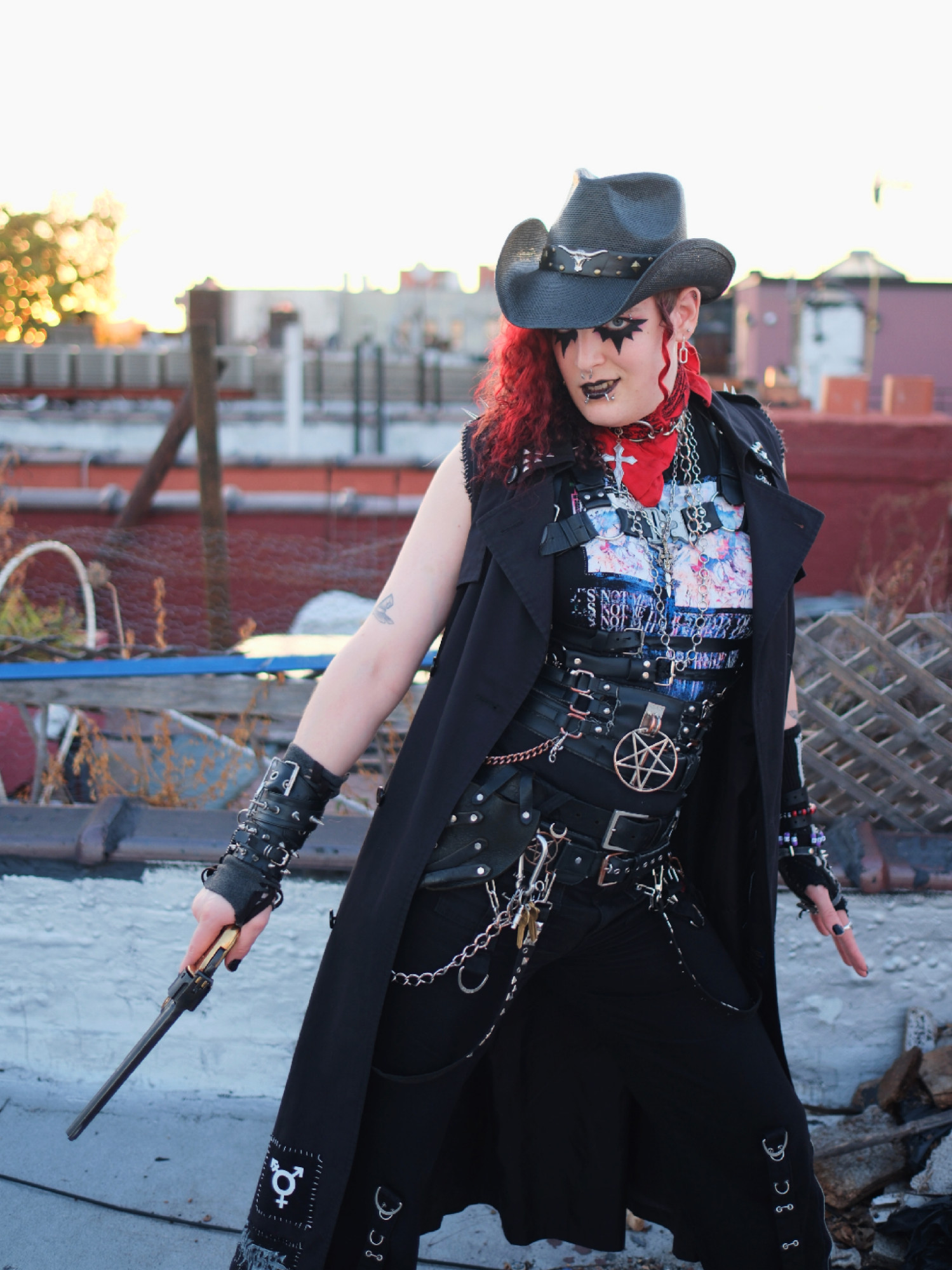 lilith with bright red hair and goth makeup wearing a cowboy outfit