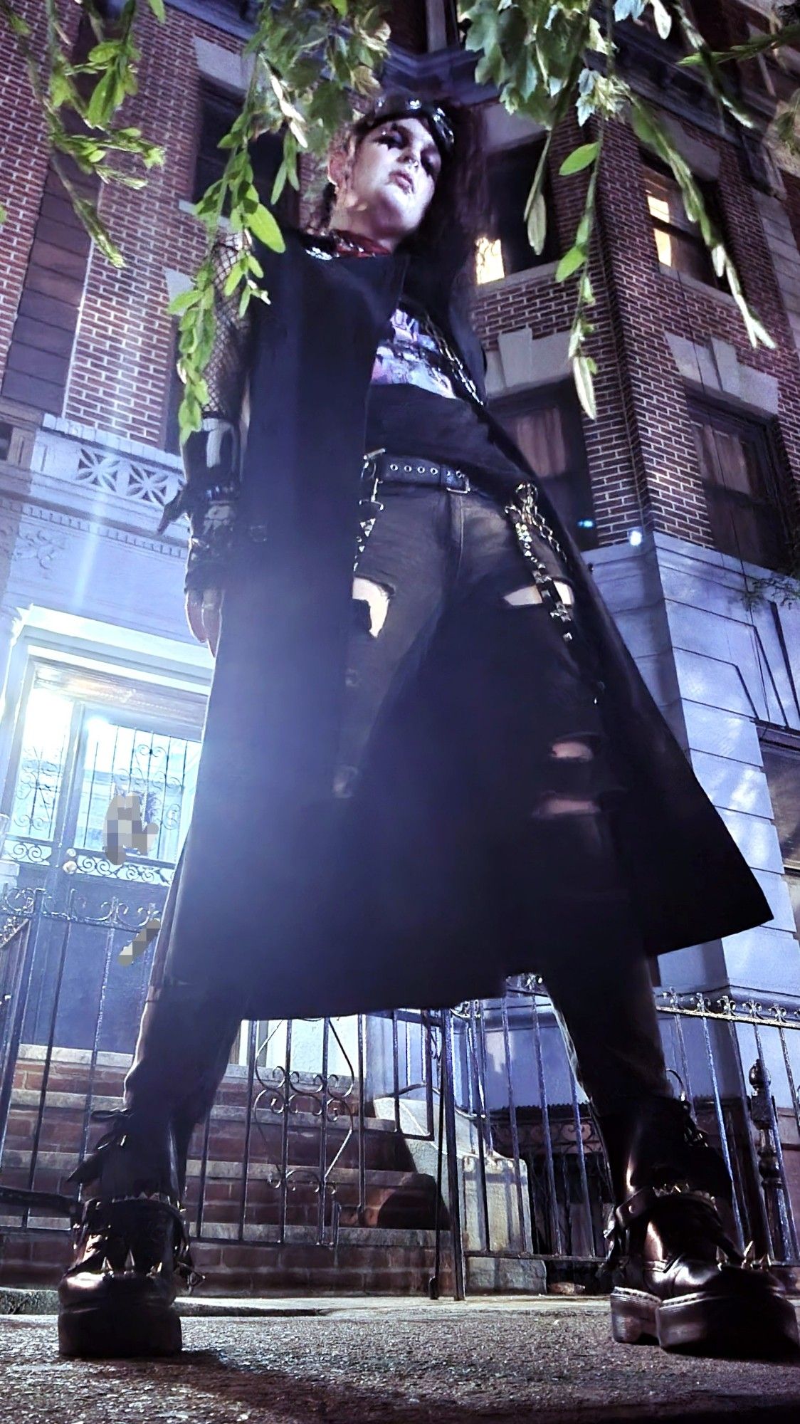 lilith wearing a sleveless trench coat shot in new york from a low angle