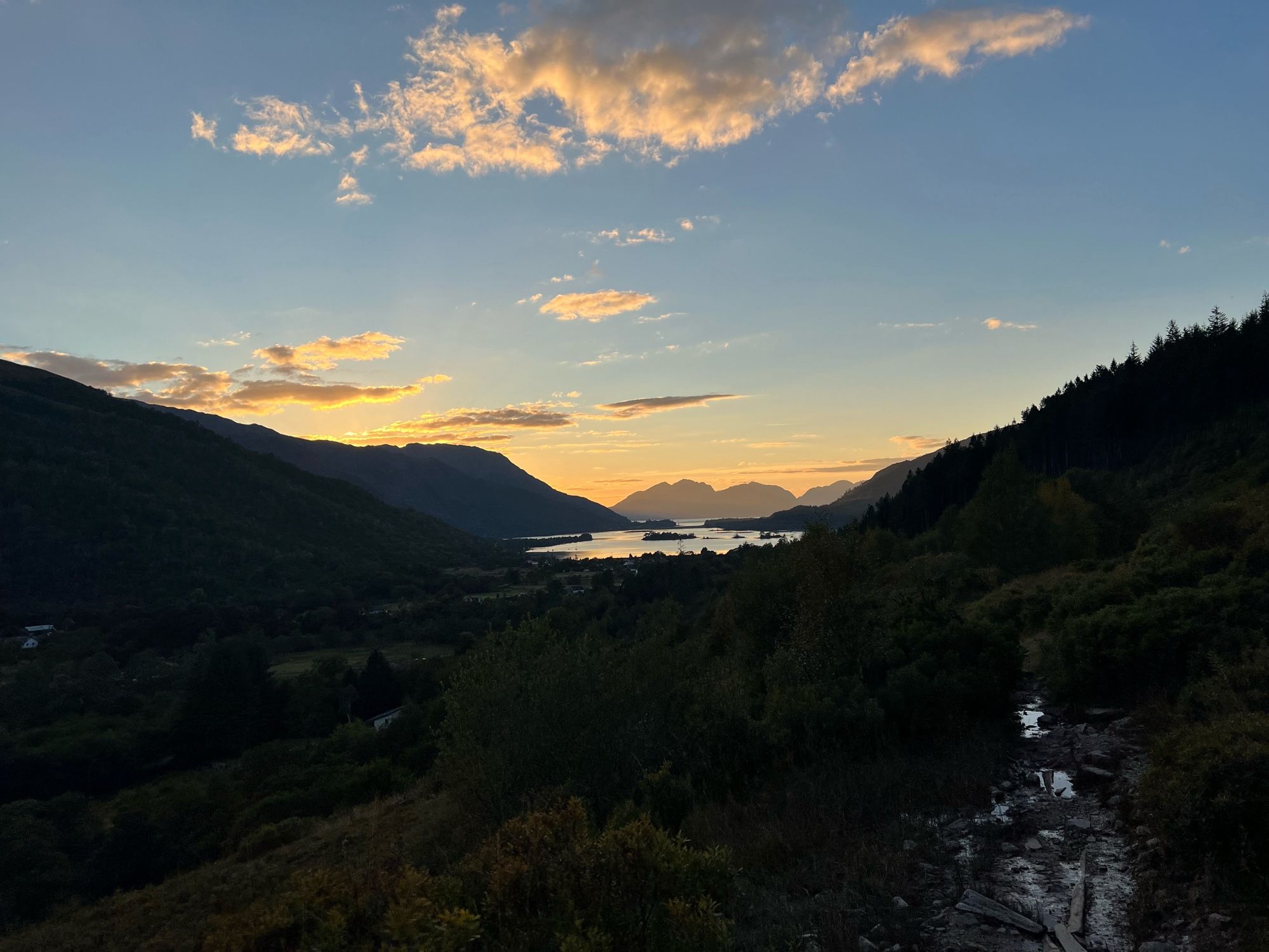 Loch Leven from the descent path of Sgorr nam Fionnaidh, with the Ardgour hills silhouetted by a reddish-blue sky as sunset approaches.