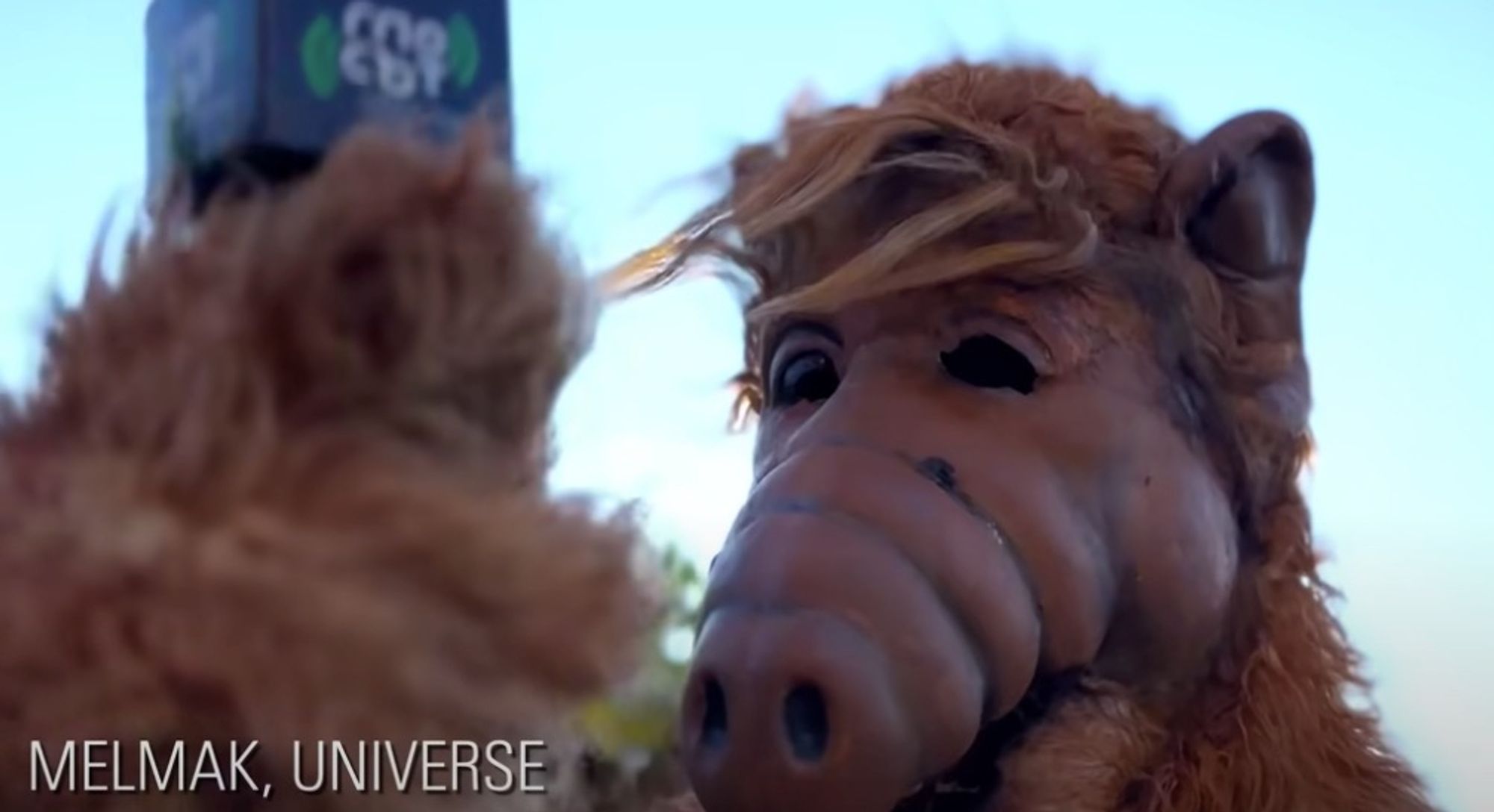 Alf in a Fiki music video holding a microphone