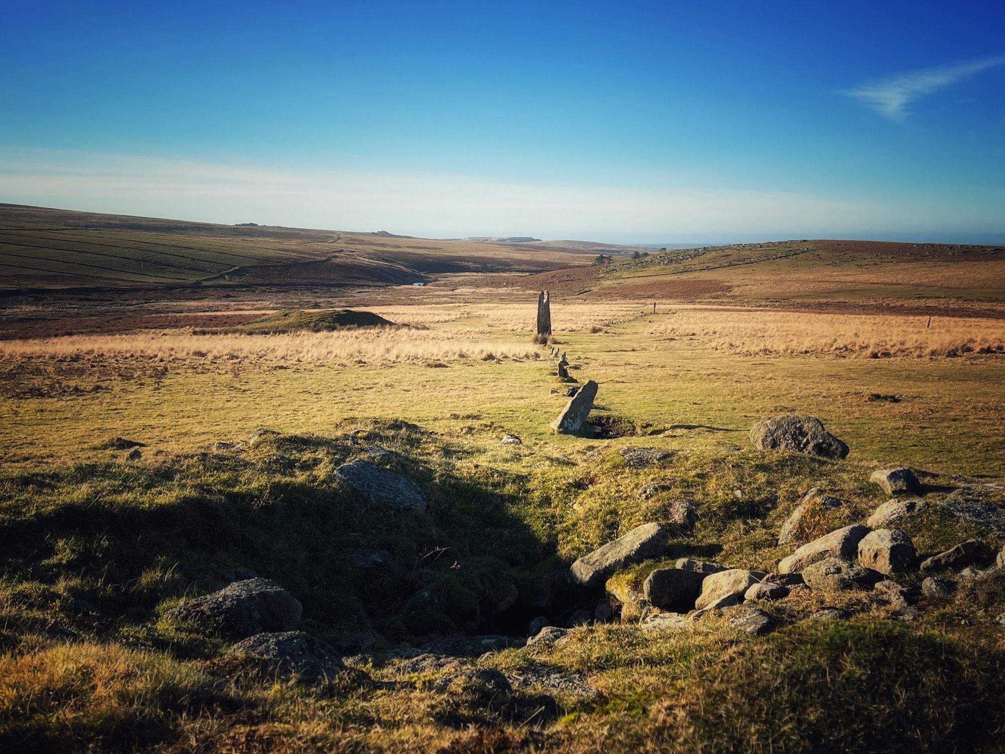 Collapsed cairn leading to stone row and menhirs