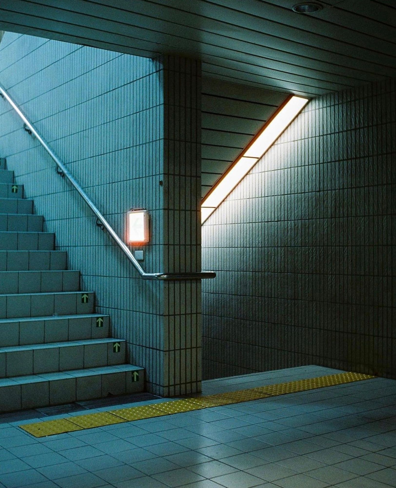 Two stairwells in a dimly lit concrete-walled building.