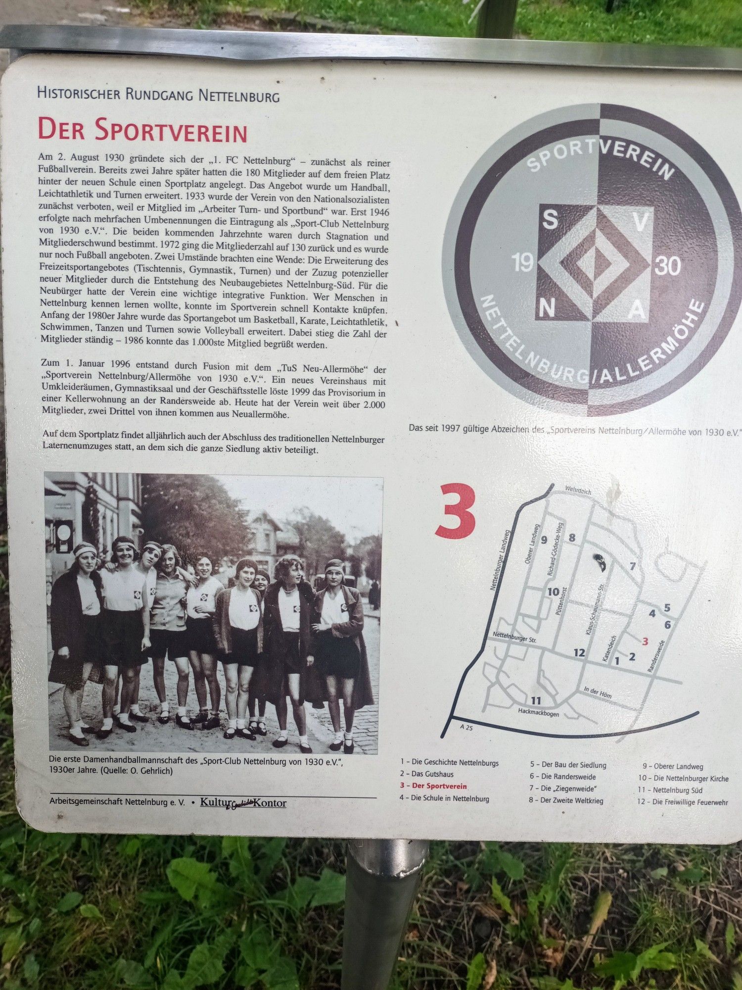 Die Kurzfassung der Geschichte des SV Nettelnburg-Allermöhe, auf einem Schild am Zugang zum Sportplatz. Auf einem Foto ist das Handballteam der Frauen, von 1930.