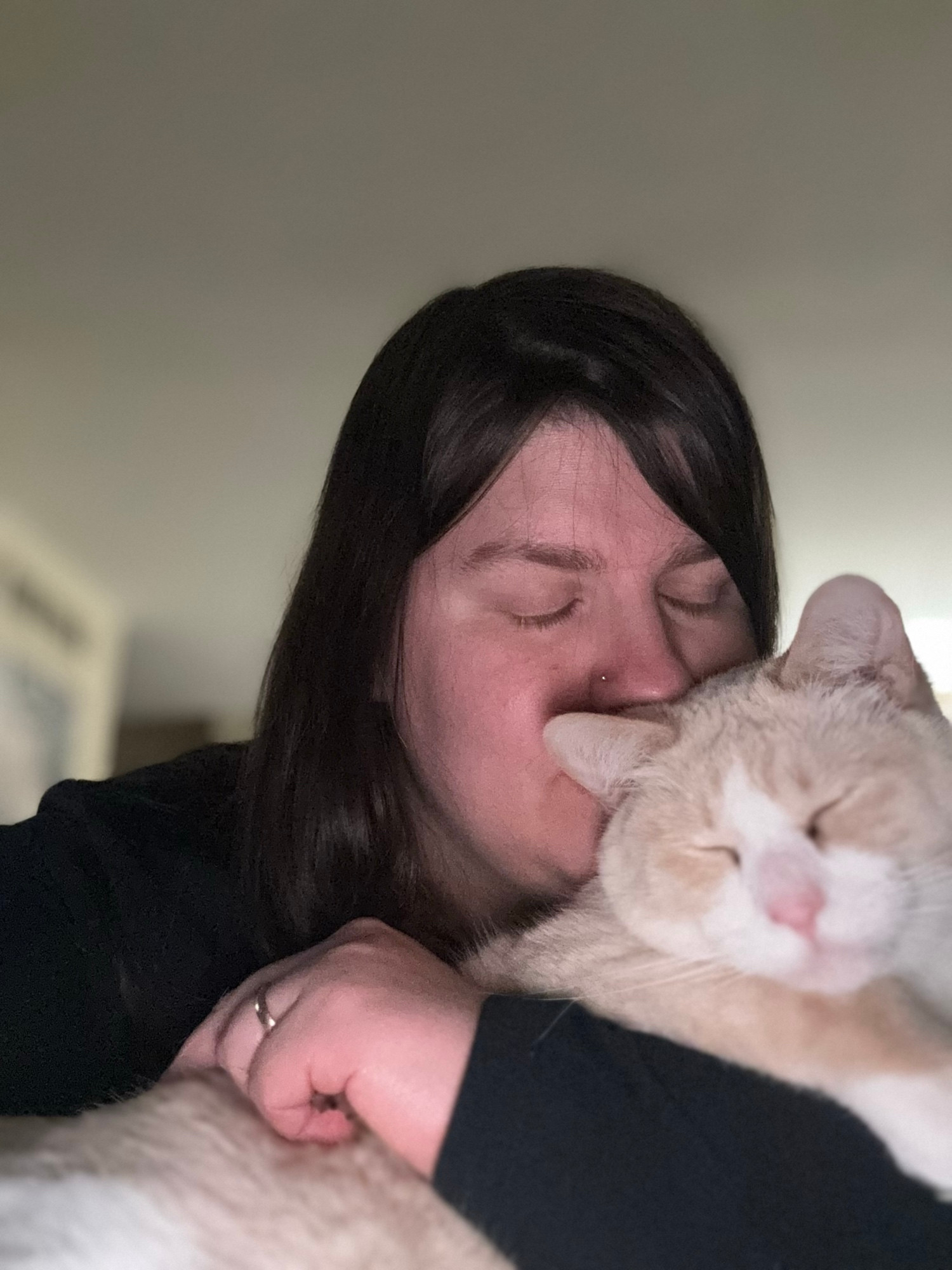 A woman kissing her smiling cat 