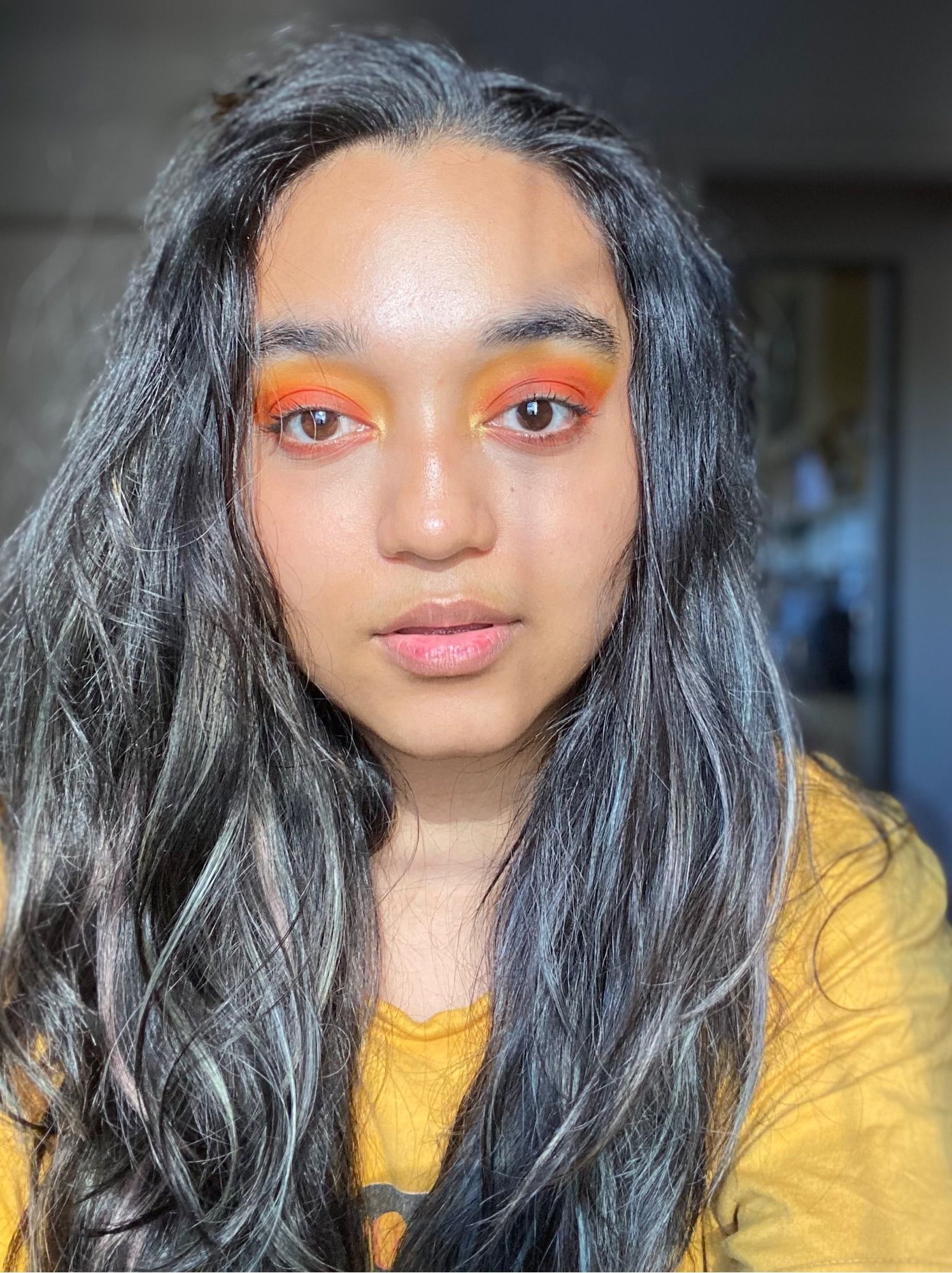 Image of Indrani - black hair, wavy, yellow tshirt, orange-yellow eyeshadow