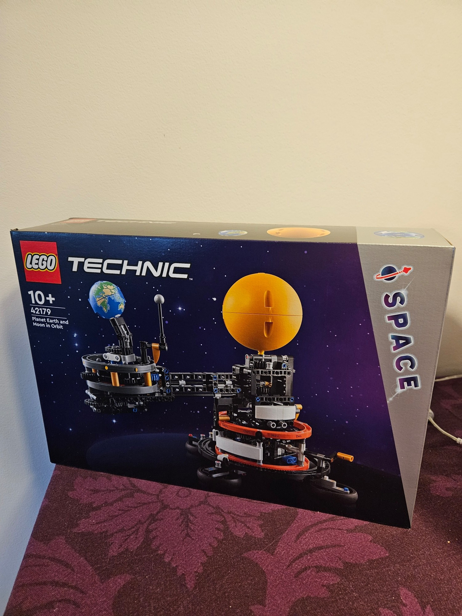 Box of a functional Lego system of sun, earth, and moon