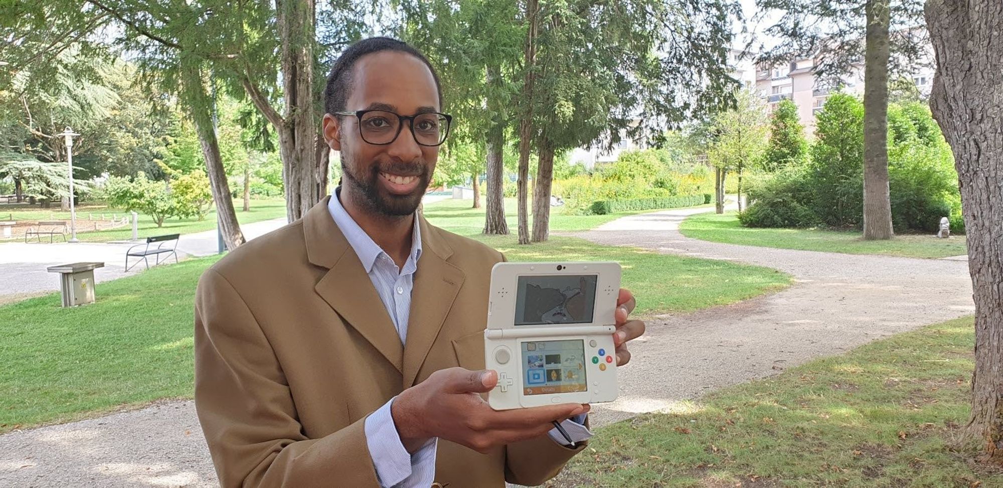 A photo of myself in the park of my town.
Smiling at the camera while holding a Nintendo new 3DS.