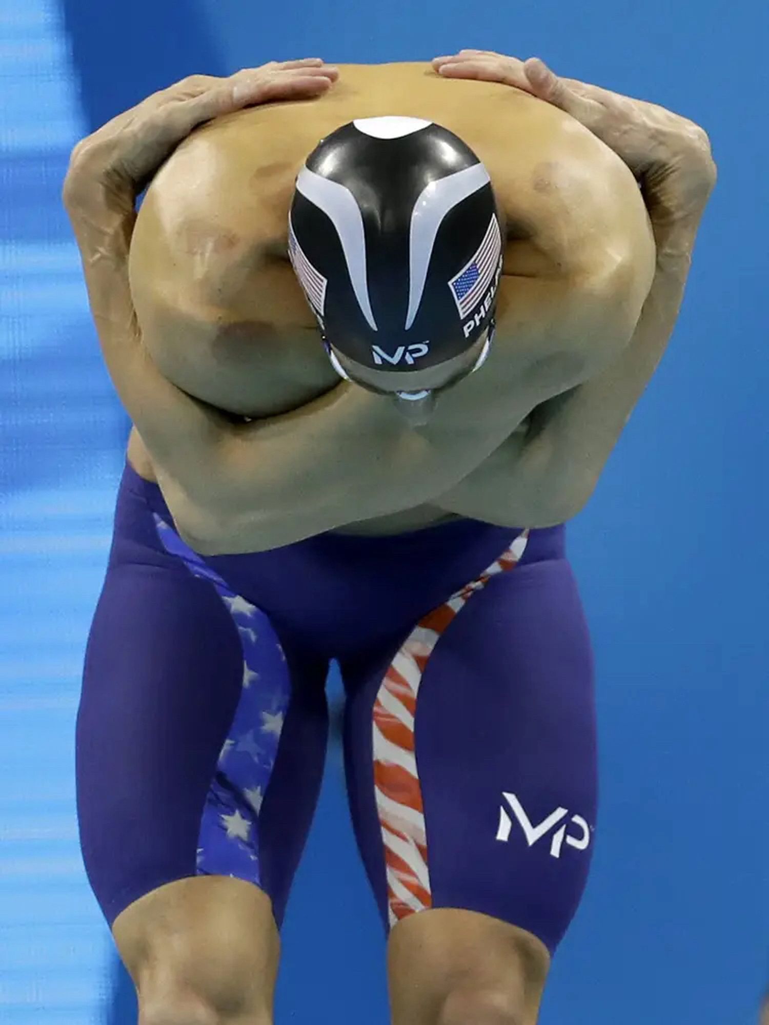 Michael Phelps with his extremely long arms wrapped tightly around himself