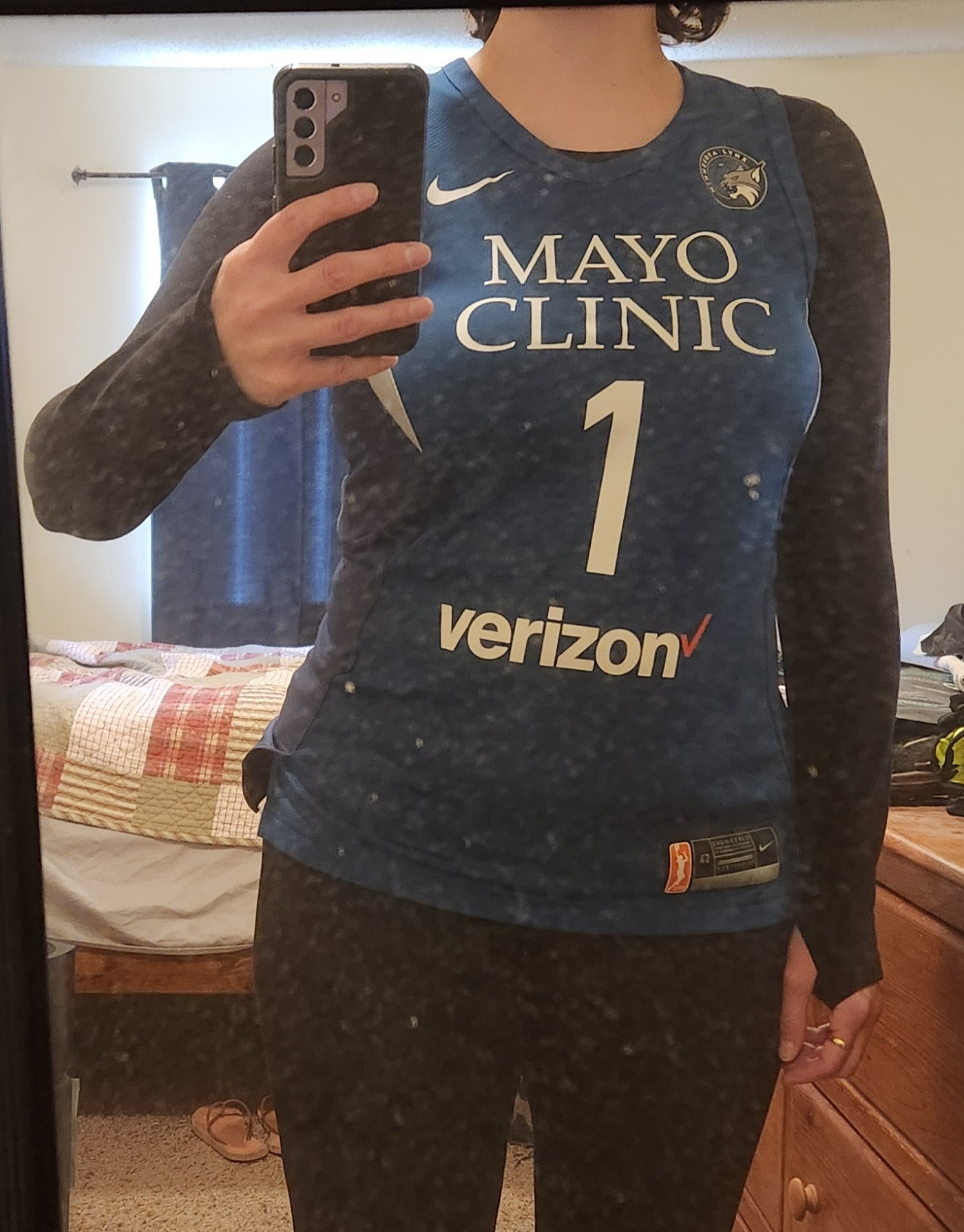 [This is a mirror selfie, so i reversed it so you could read it. Blue basketball jersey for the Minnesota Lynx; Mayo Clinic and Verizon are prominent; very small Lynx logo in the upper right hand corner]