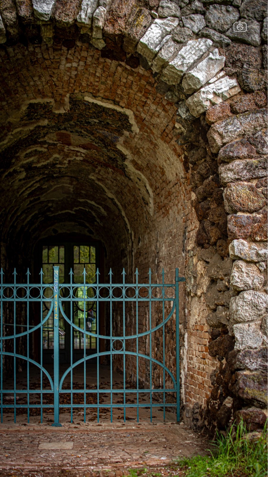 Closed iron gate leading to a stone grotto. Muschelgrotte (Shell Grotto), New Garden, Potsdam, 22 Apr 2024. Nikon D5600, Nikkor DX 35 mm ƒ1.8G, ISO 180, ƒ2.2, -0.3 ev, 1/100s