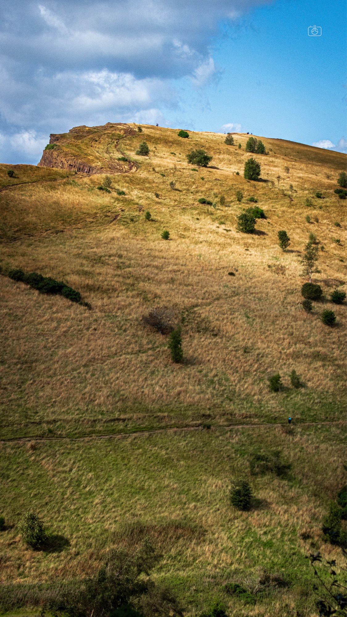 Steep hillside leading up to a blue sky. Arthur’s Seat, Holyrood Park, Edinburgh, 23 Aug 2024. Nikon D5600, Nikkor DX 35 mm ƒ1.8G, ISO 1000, ƒ4.5, -0.3 ev, 1/3200s, polarizing filter